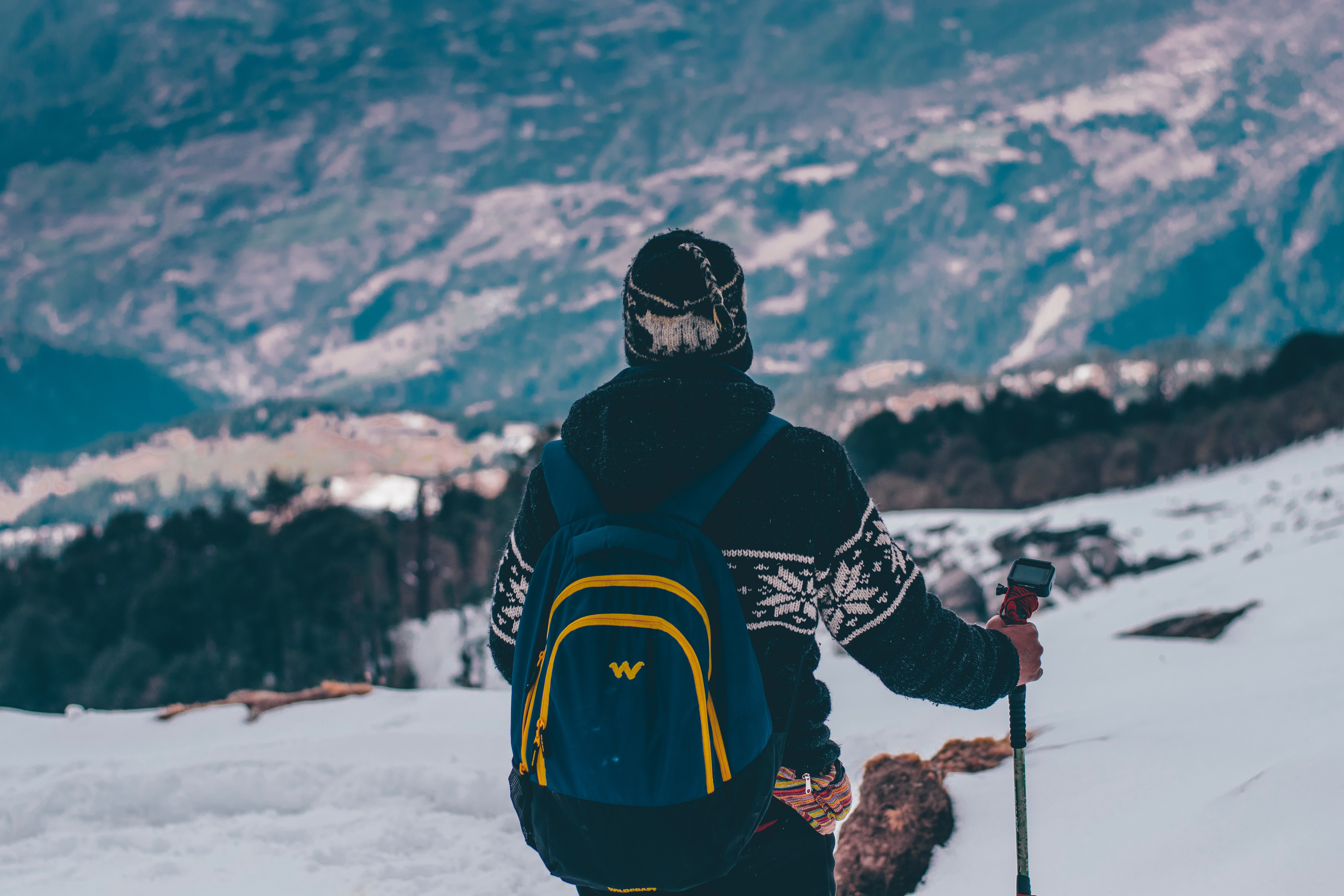 Man in black and white jacket and blue backpack doing snow ski photo