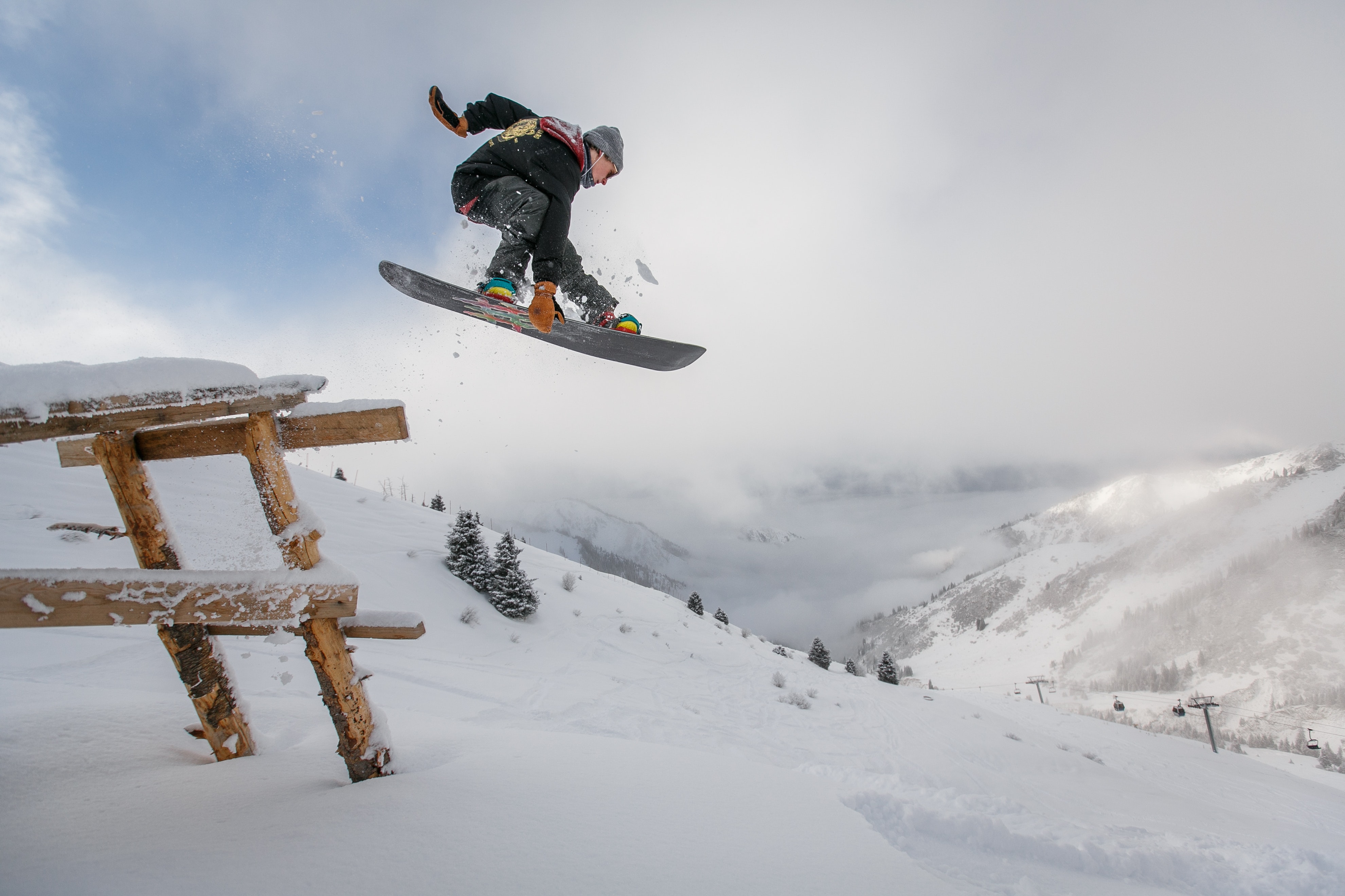 Man in black snowboard with binding performs a jump photo