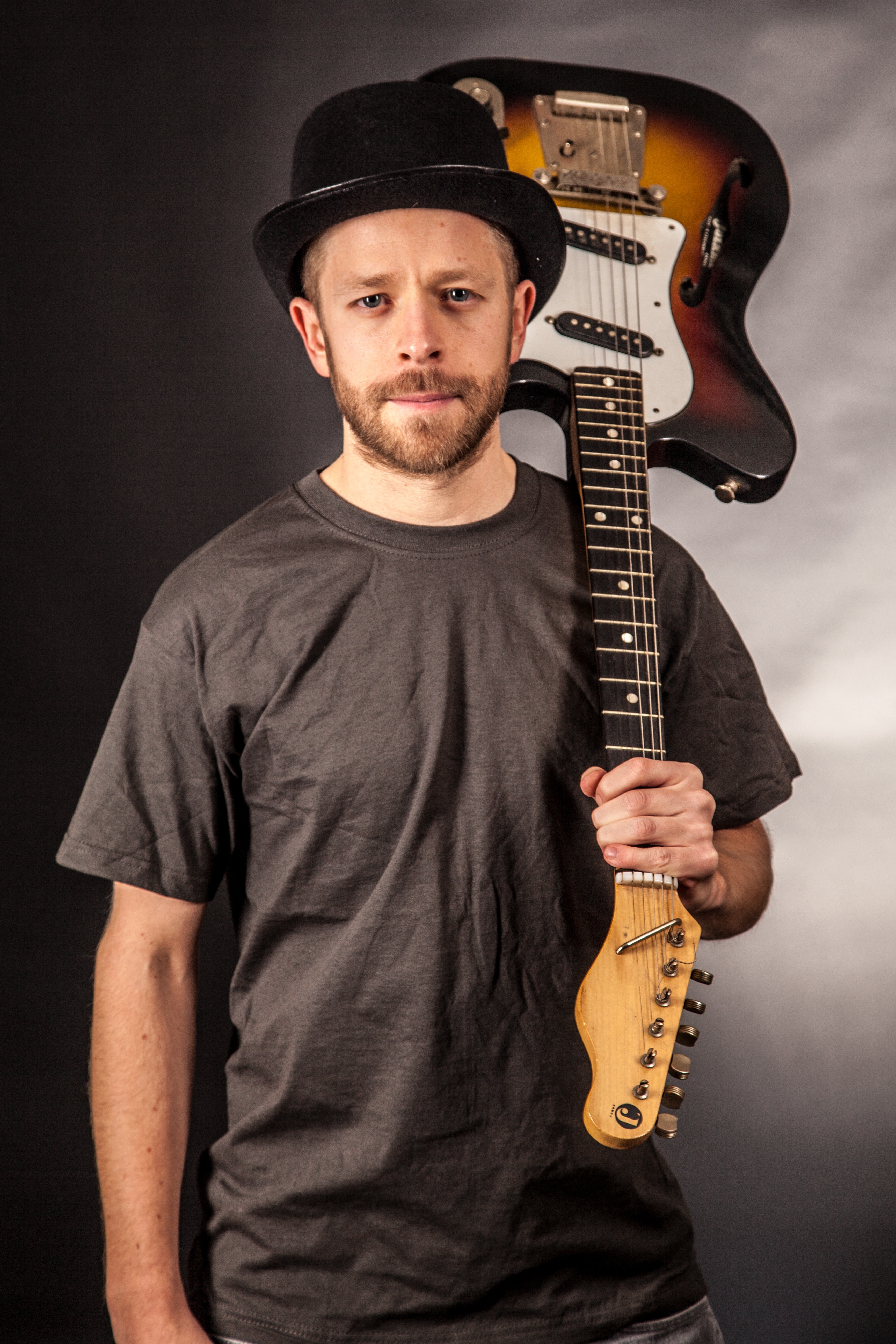 Man in black t shirt holding electric guitar upside down photo