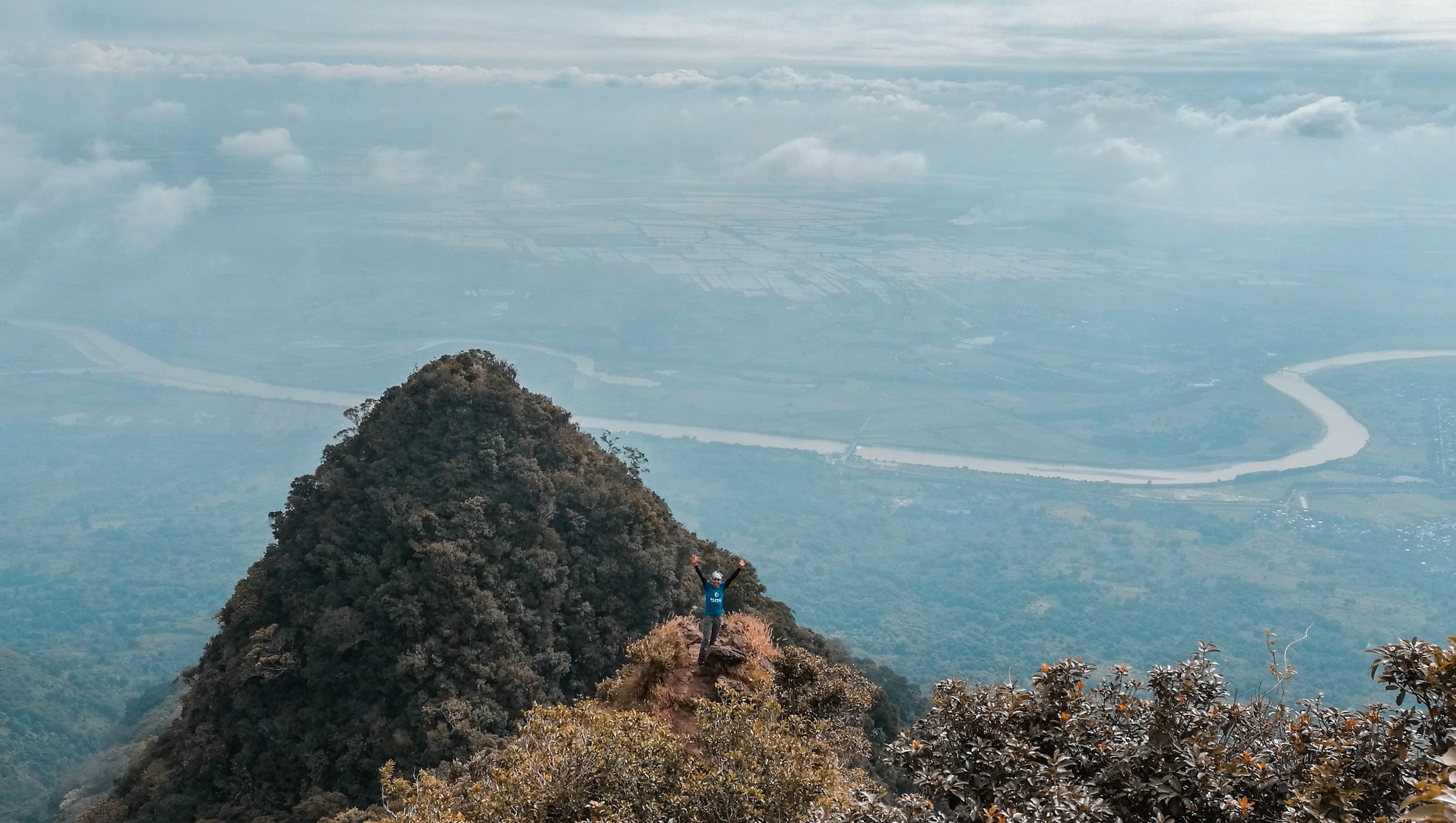 Man in blue on top of the mountain with areal view photo