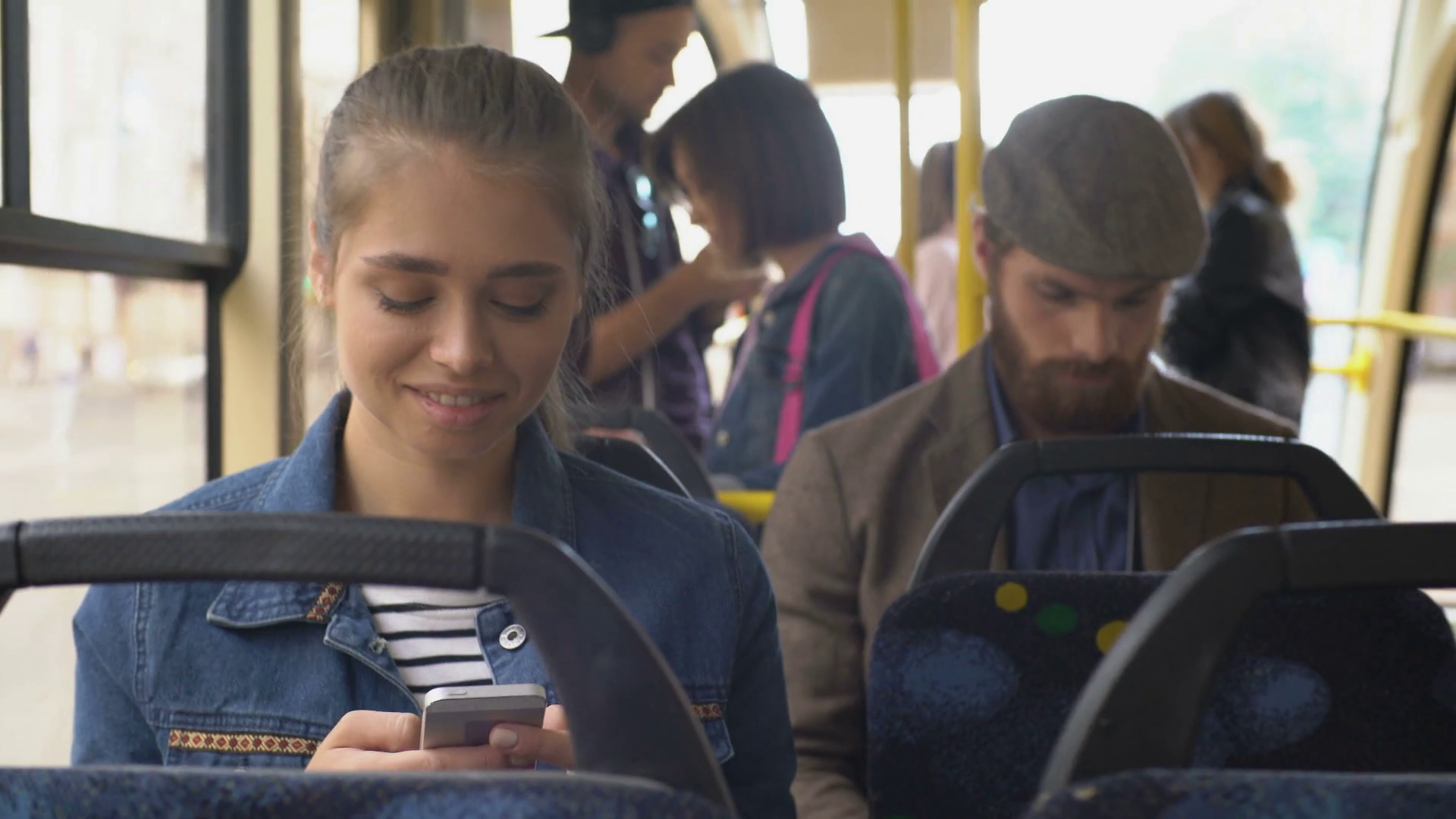 Handheld shot of young woman and man with beard sitting in bus and ...