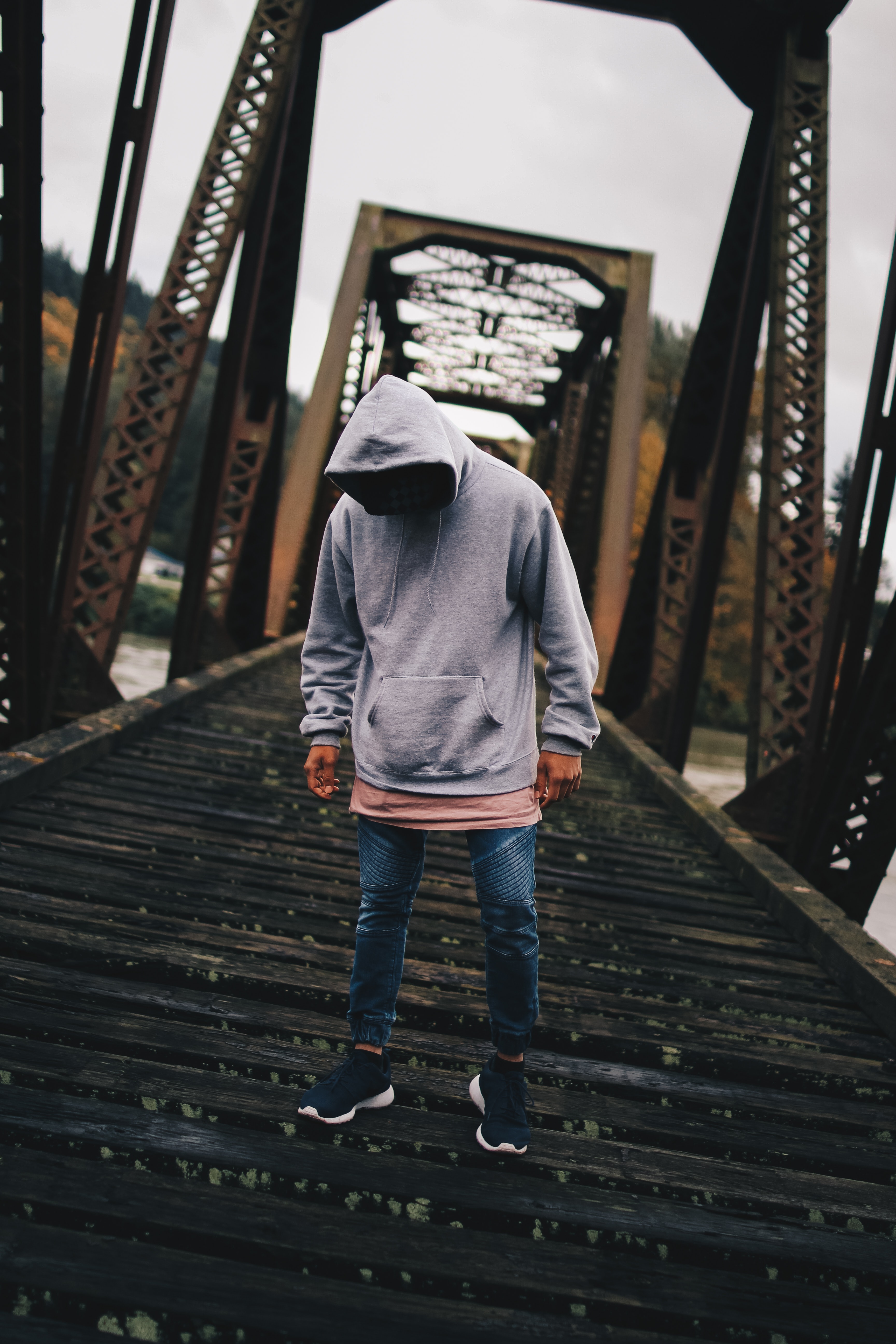 Man in gray pull-over hoodie standing on train rail photo