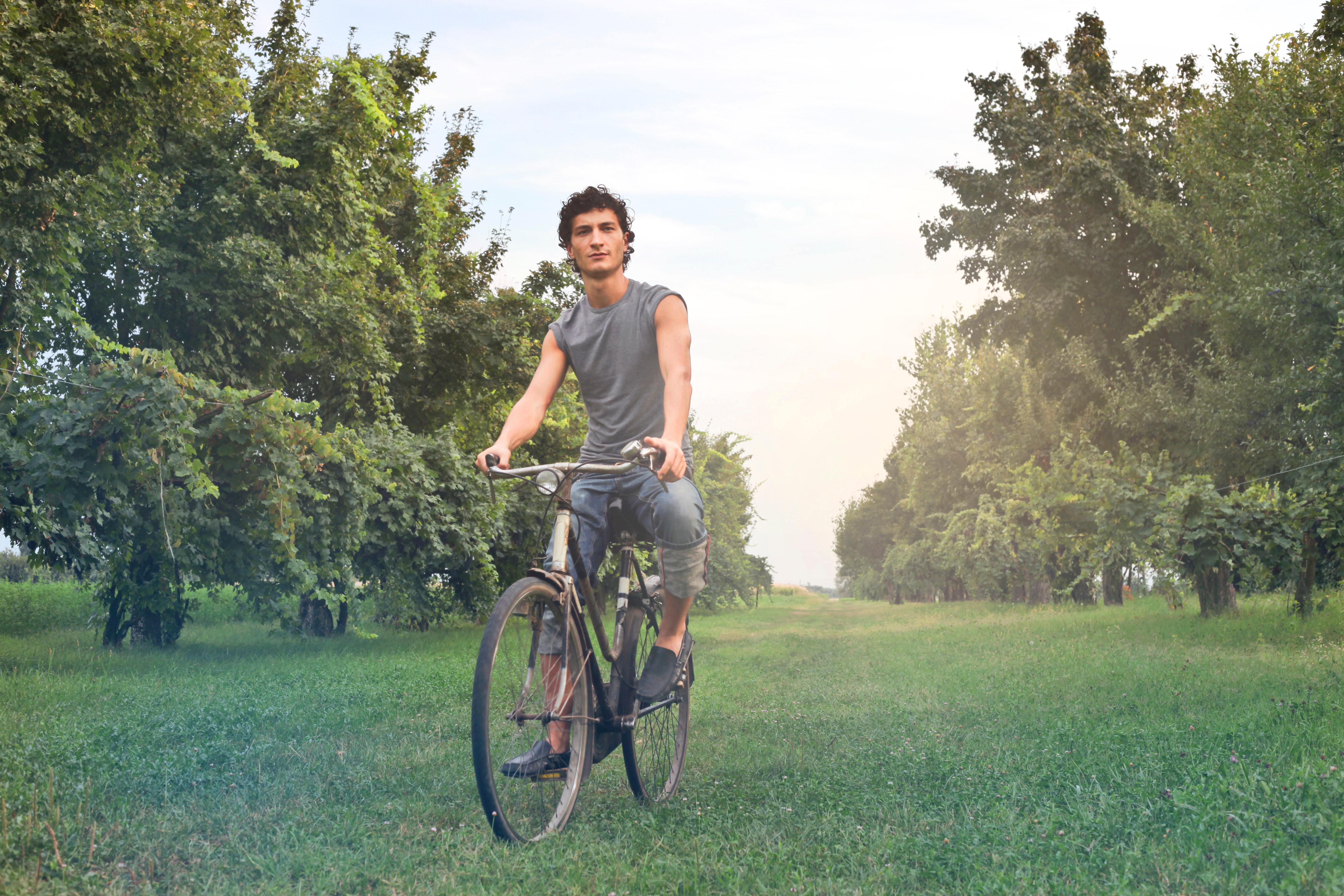 Man in gray sleeveless shirt riding bike photo