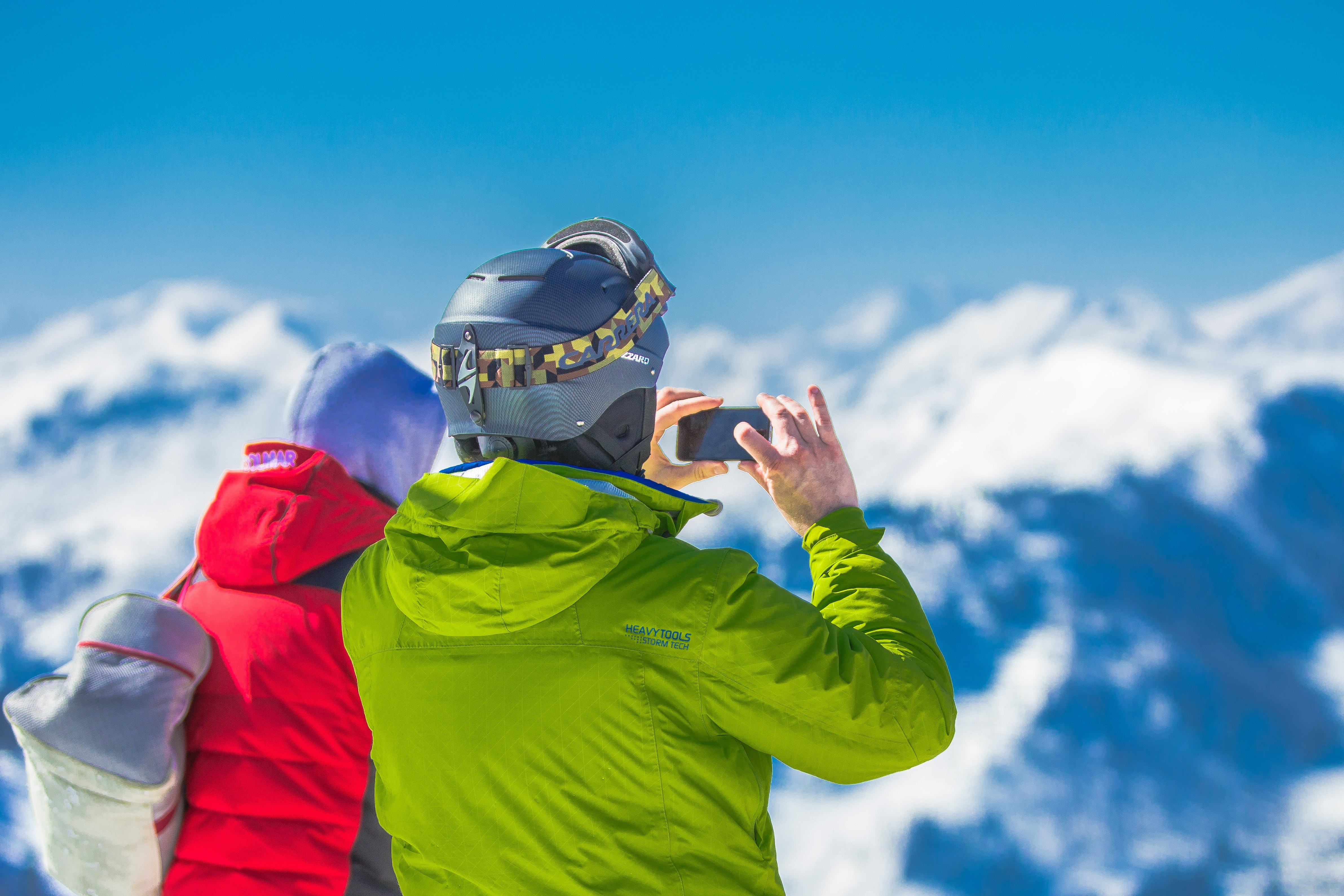 Man in Green Jacket and Gray Helmet Holding Phone Standing Next to Person in Red and Black Jacket, Active, People, View, Vacation, HQ Photo