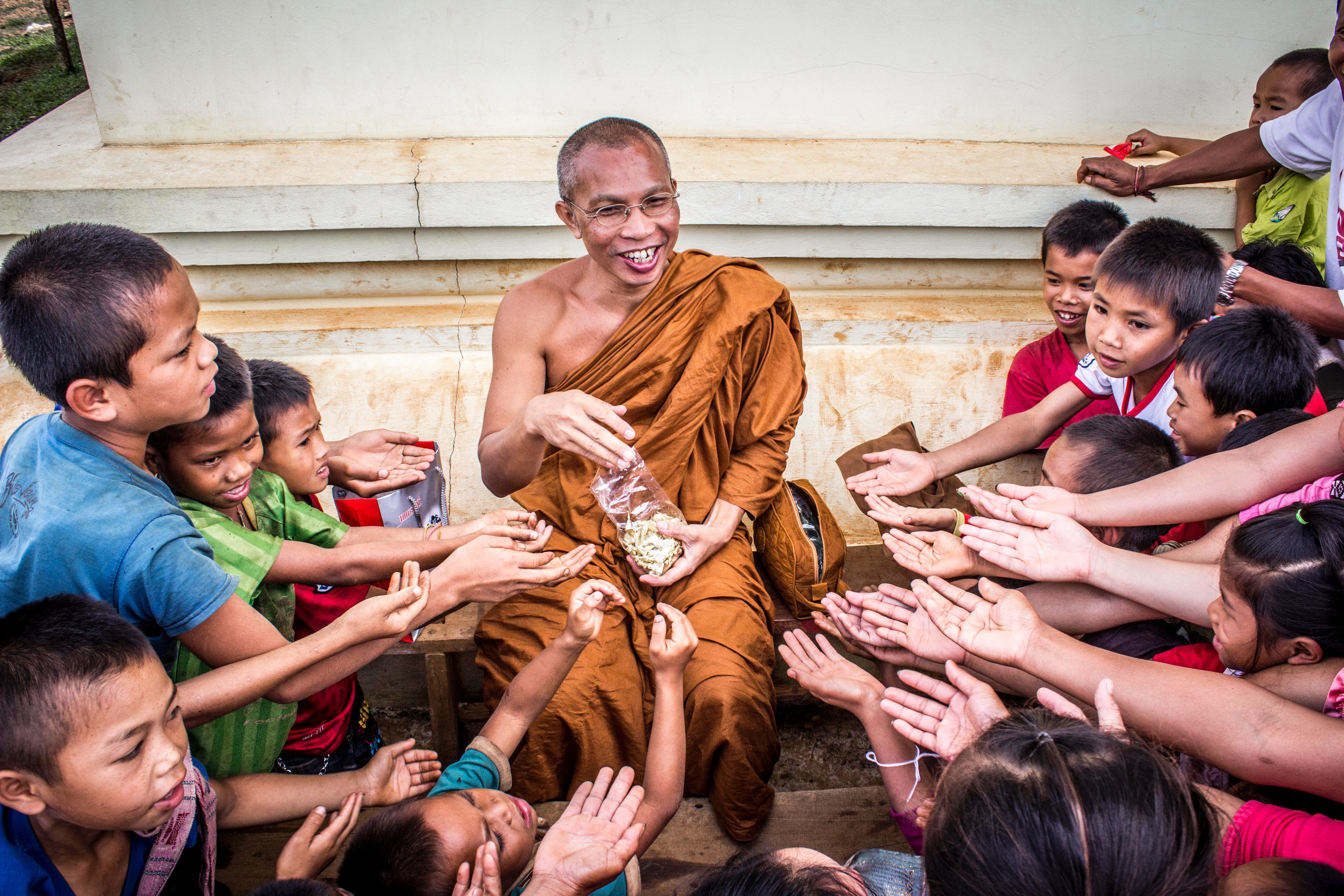 Man in monk dress between group of children photo