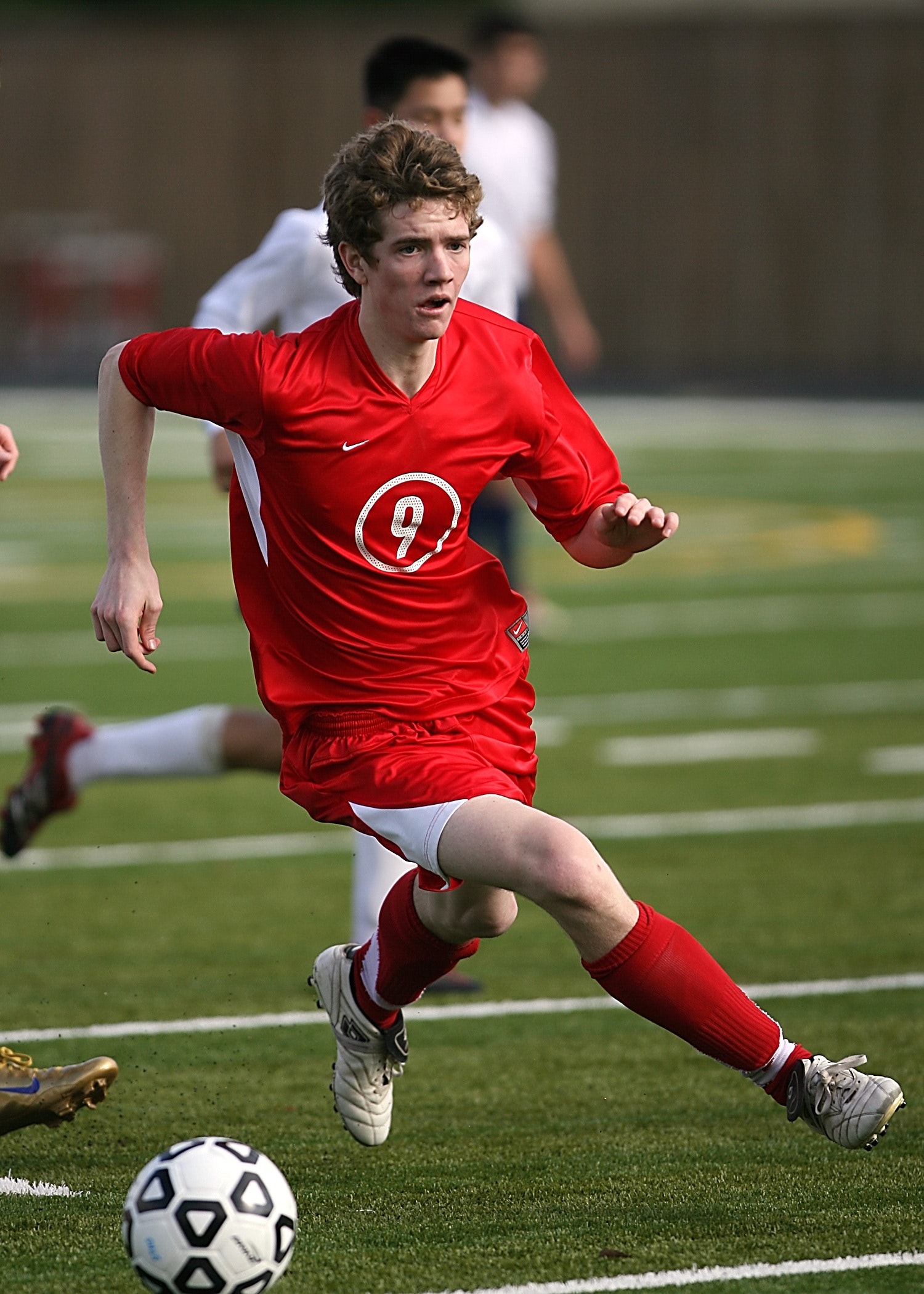 Man in red nike jersey shirt playing soccer photo