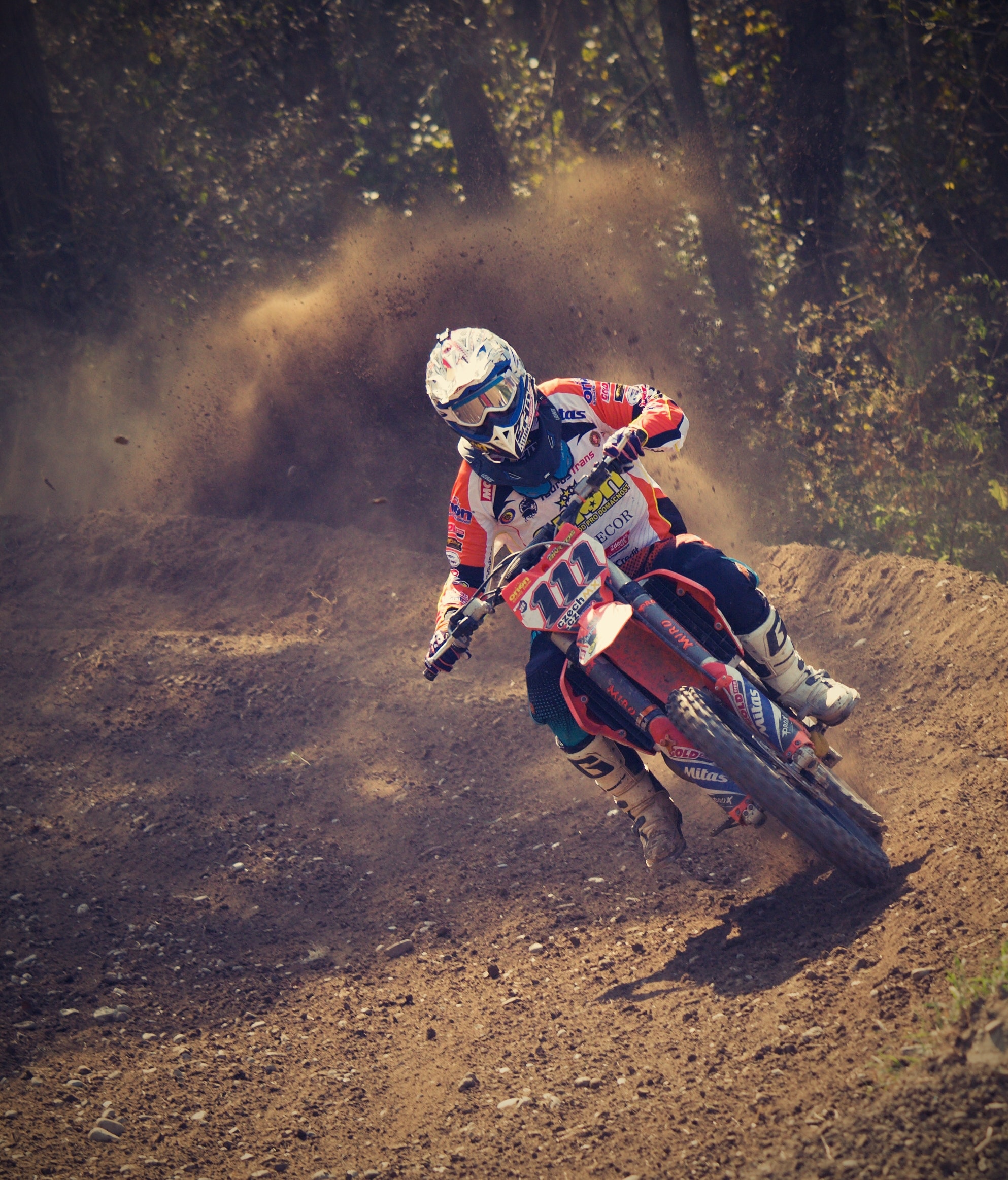 Man in white and orange motocross overall riding his motocross dirt bike during daytime photo