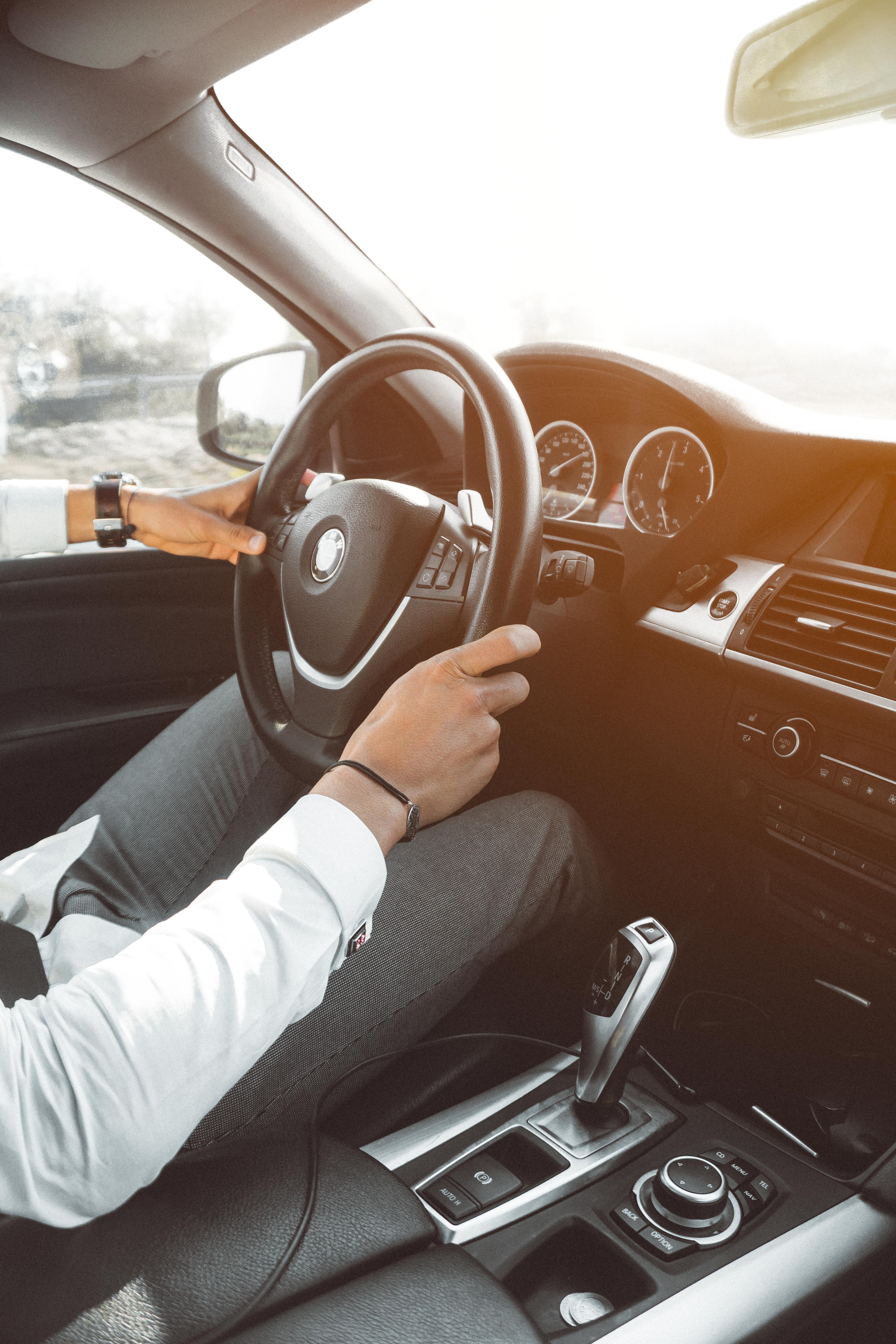 Man in white dress shirt holding steering wheel photo