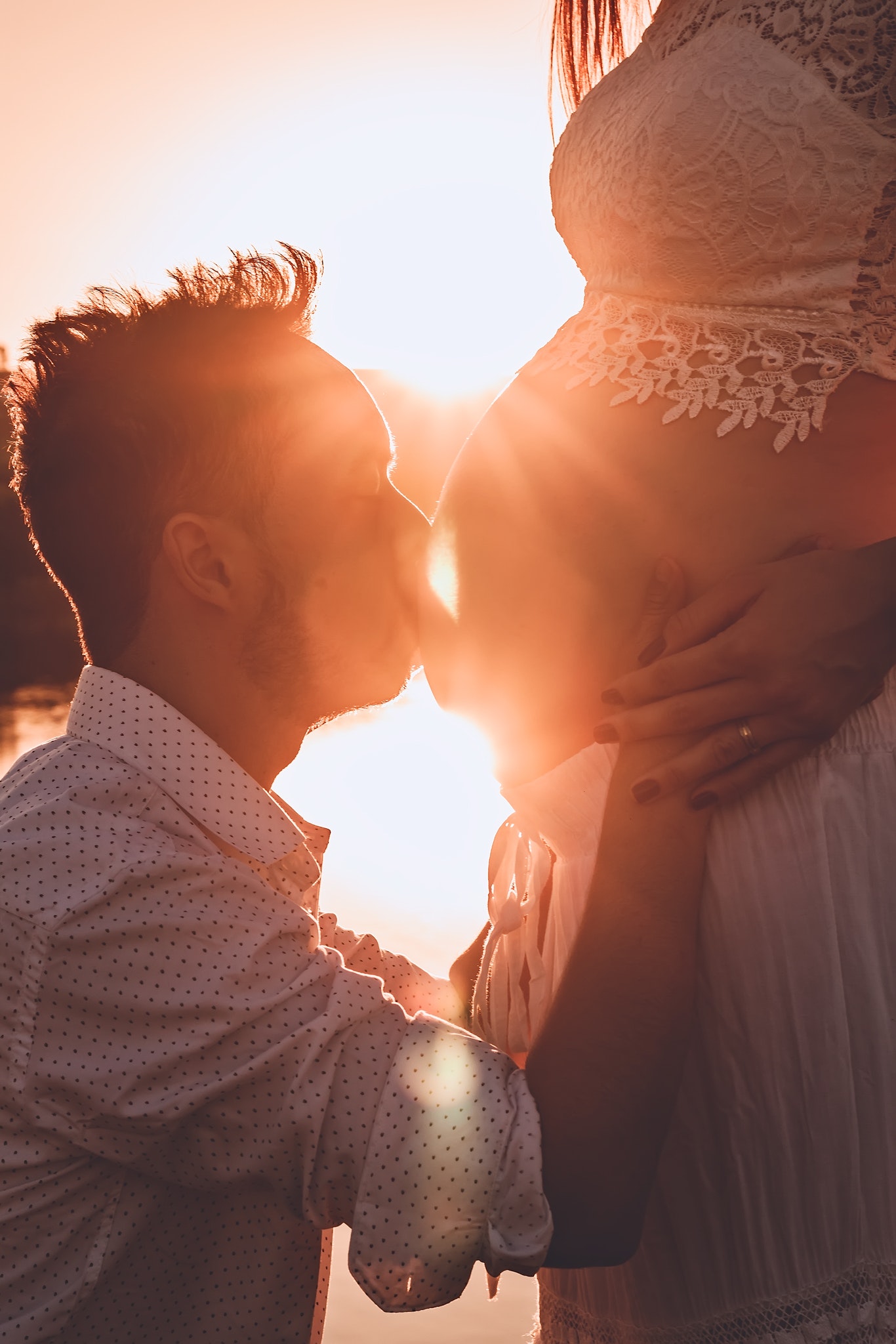 Man kissing woman's belly photo