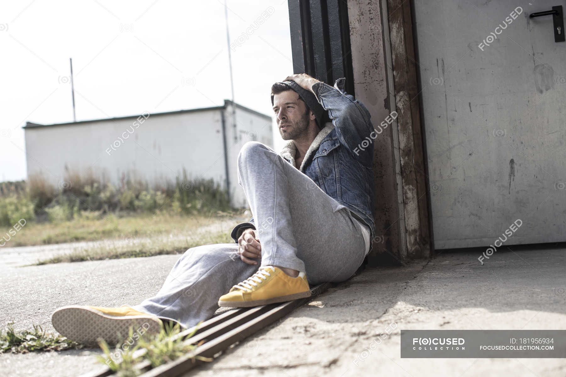 Thoughtful Man sitting on ground and leaning on wall — Stock Photo ...