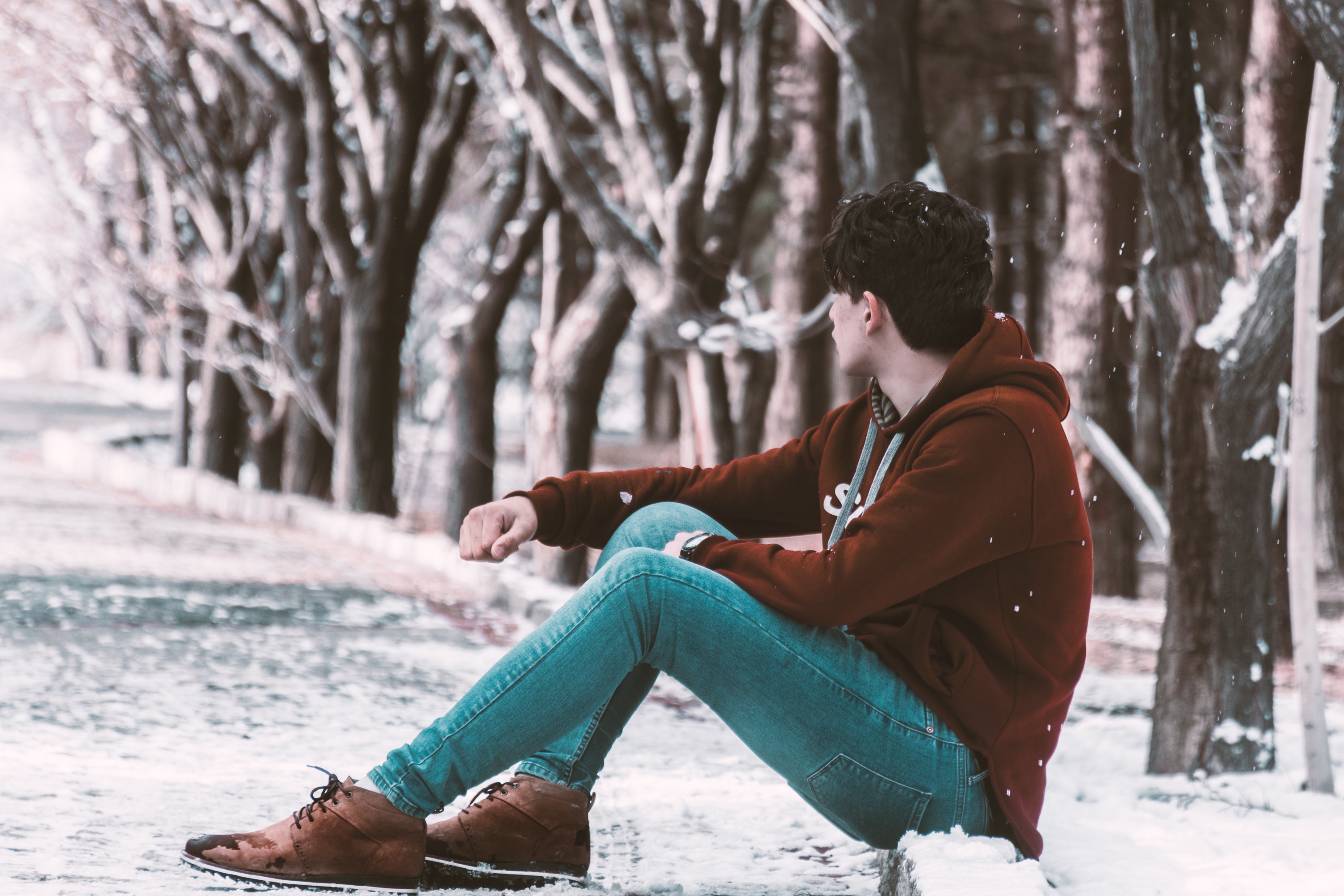 Man sitting on ground with snow photo