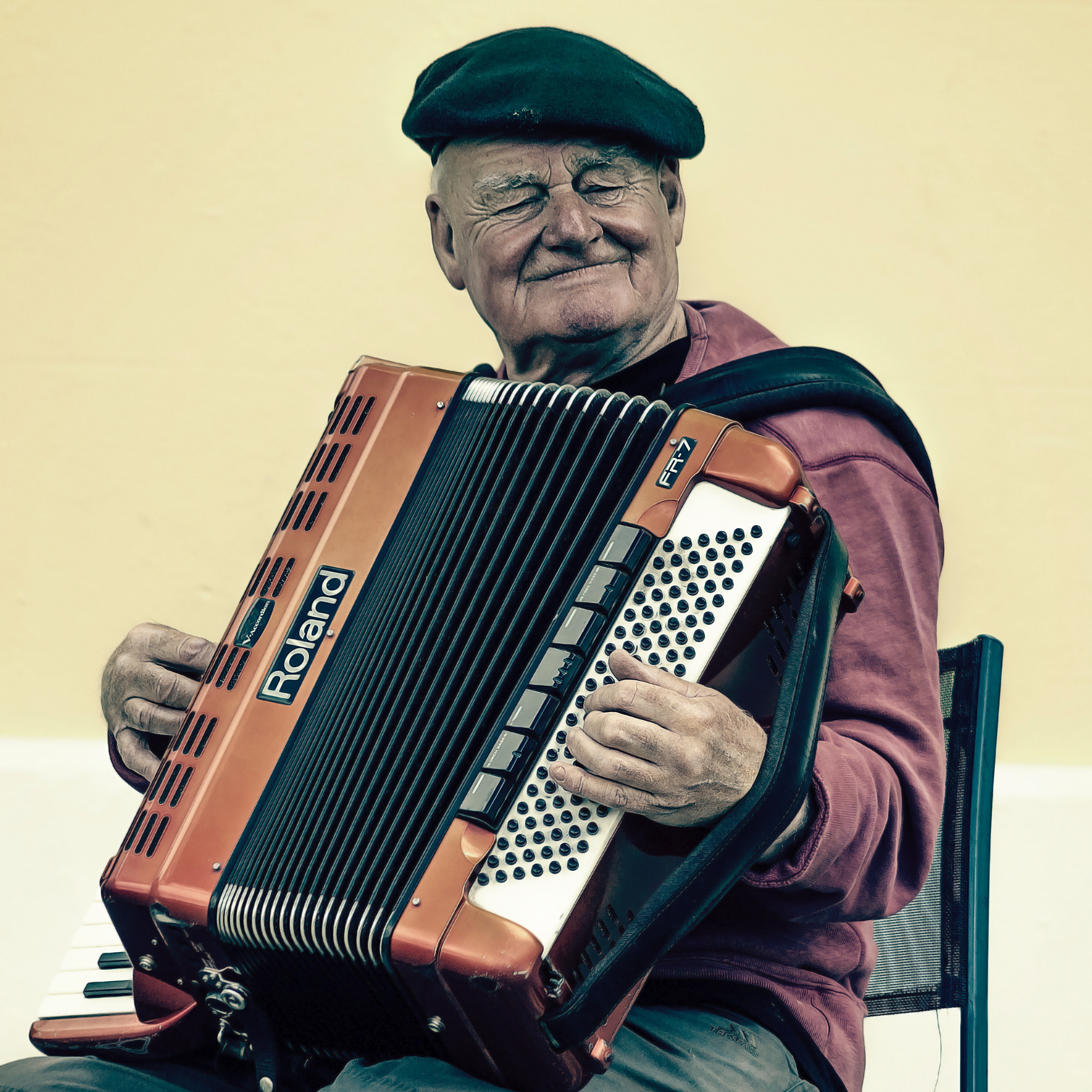 Man sitting playing accordion photo