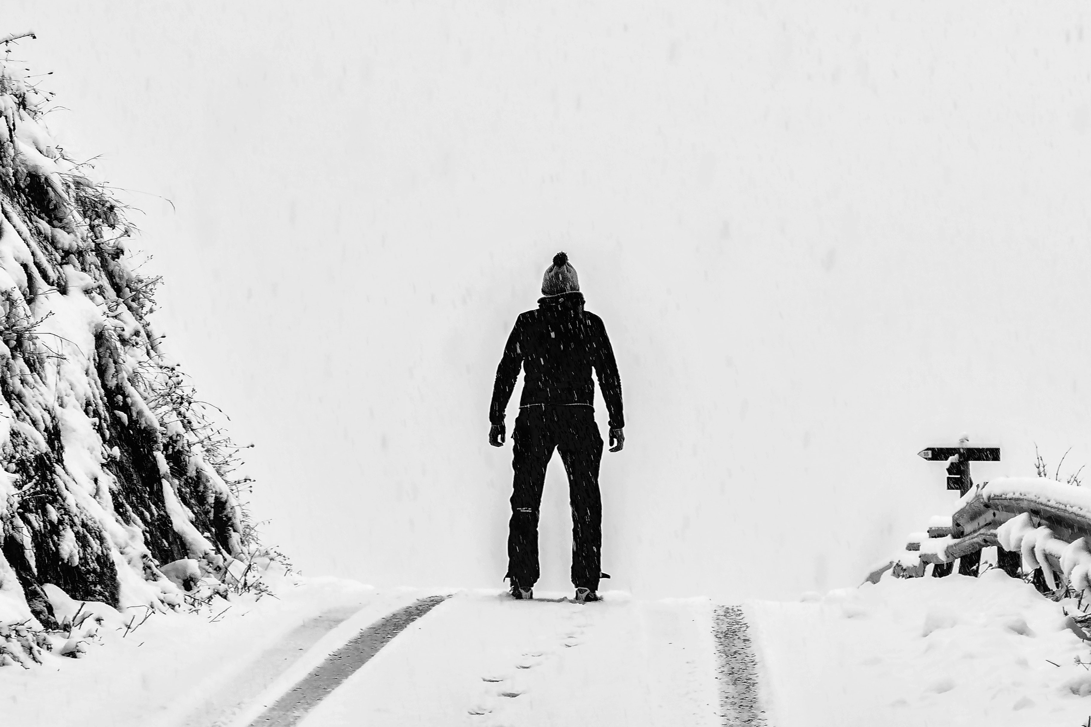 Man standing on white snow covered ground beside mountain photo