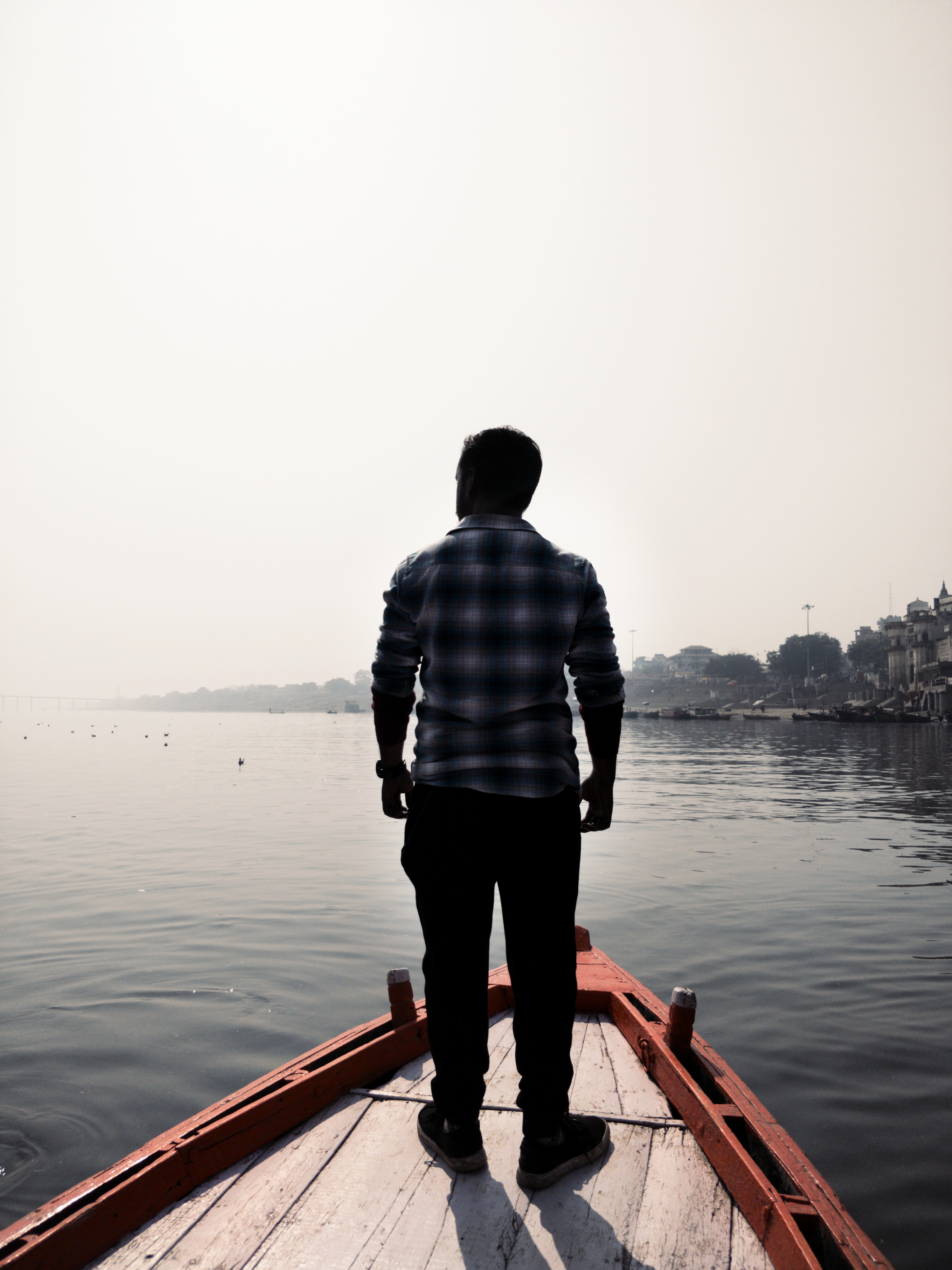 Man standing on wooden boat photo