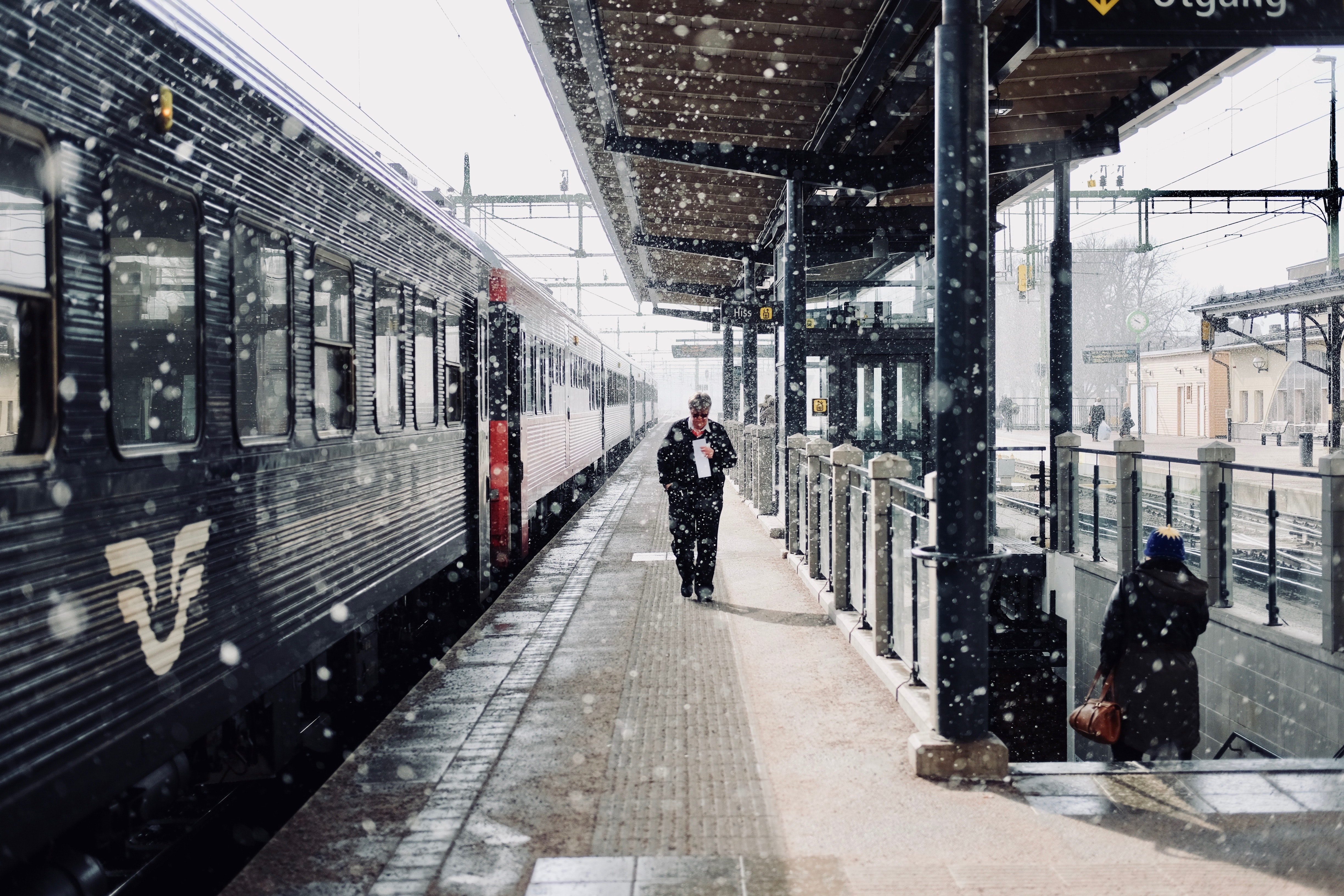 Man walks beside train photo