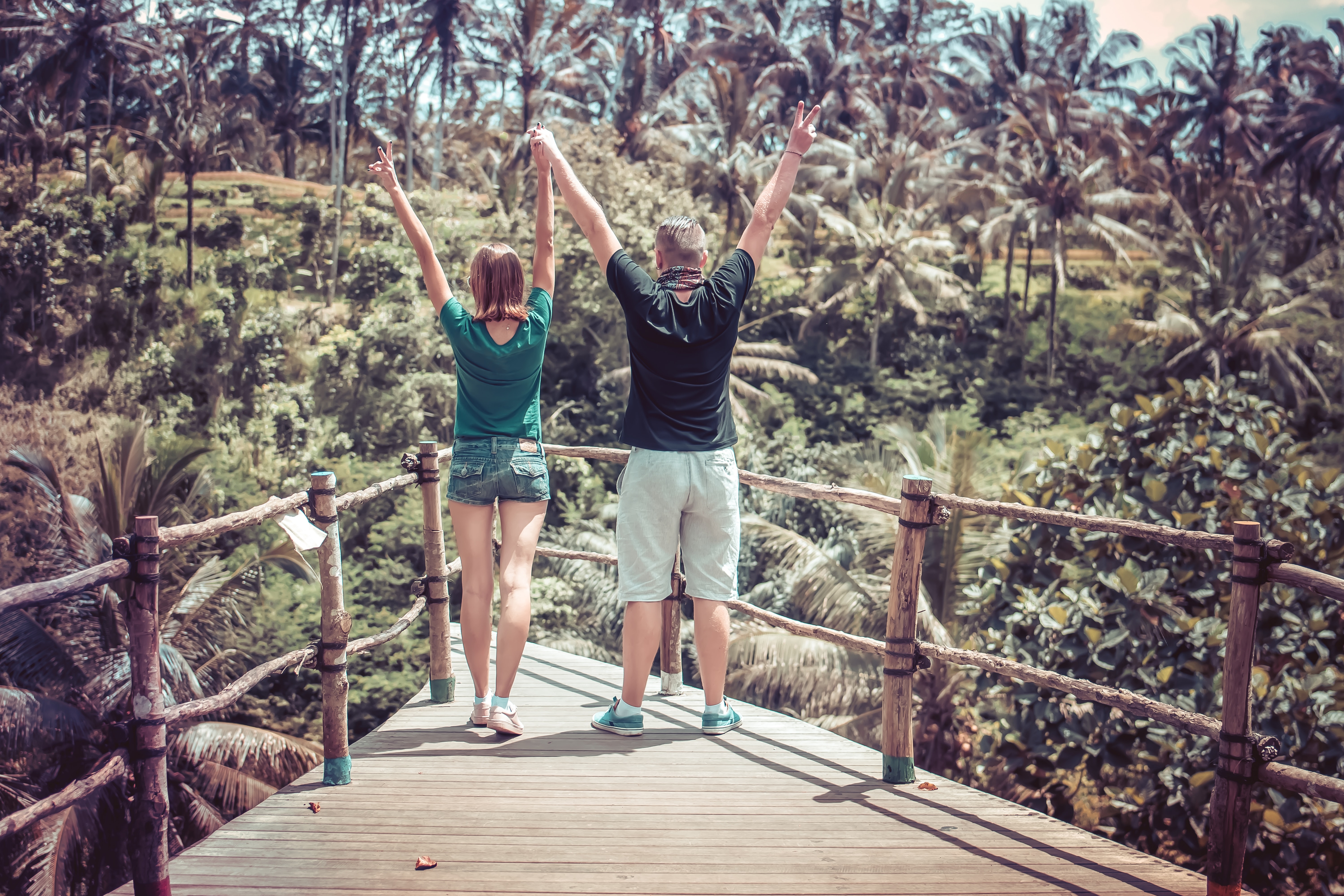 Man Wearing Black Shirt Beside a Woman in Green Shirt Raising Their Hands in the Air, Adult, Togetherness, Palm trees, People, HQ Photo