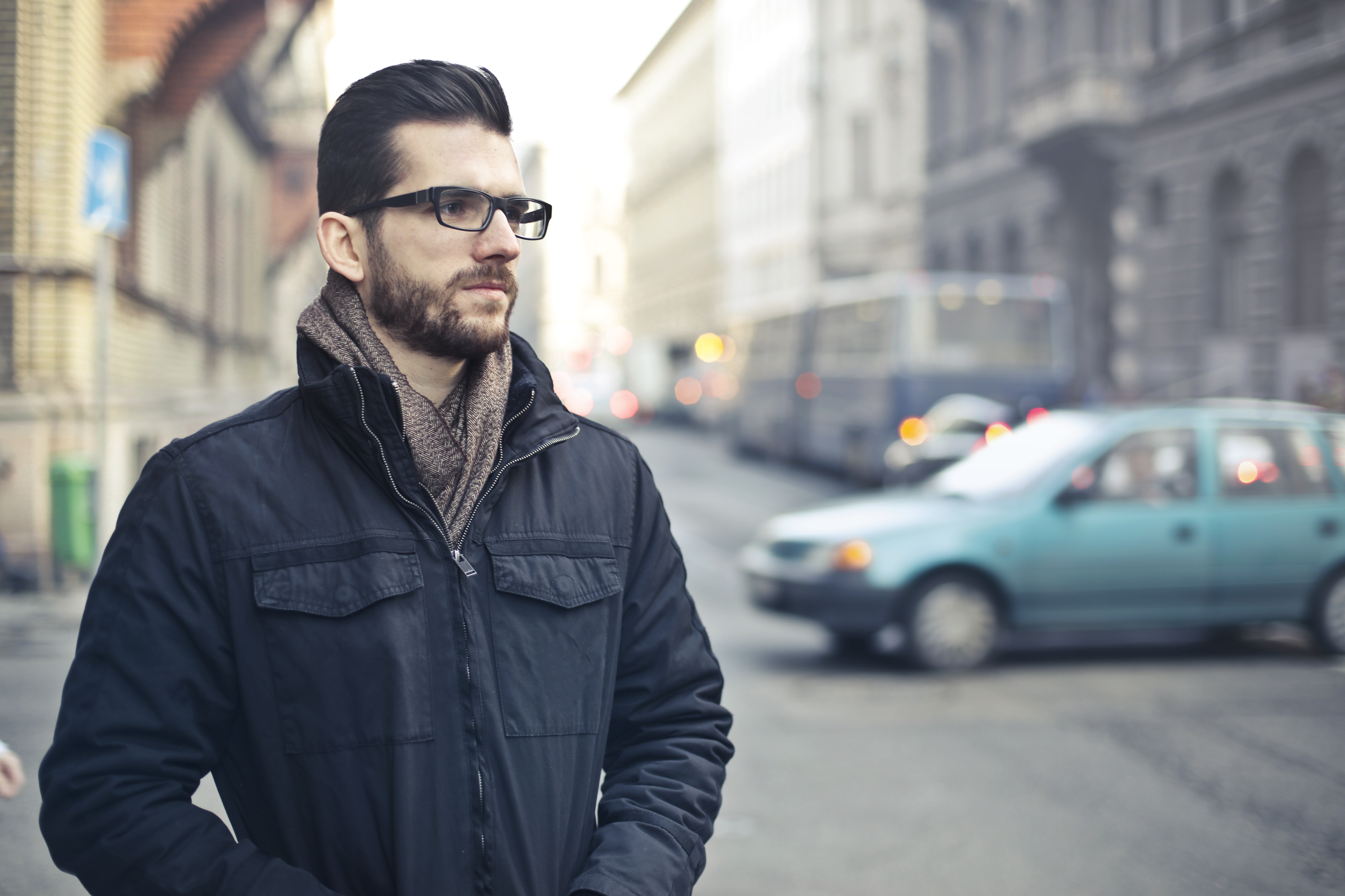 Man wearing black zip-up jacket standing on the street photo