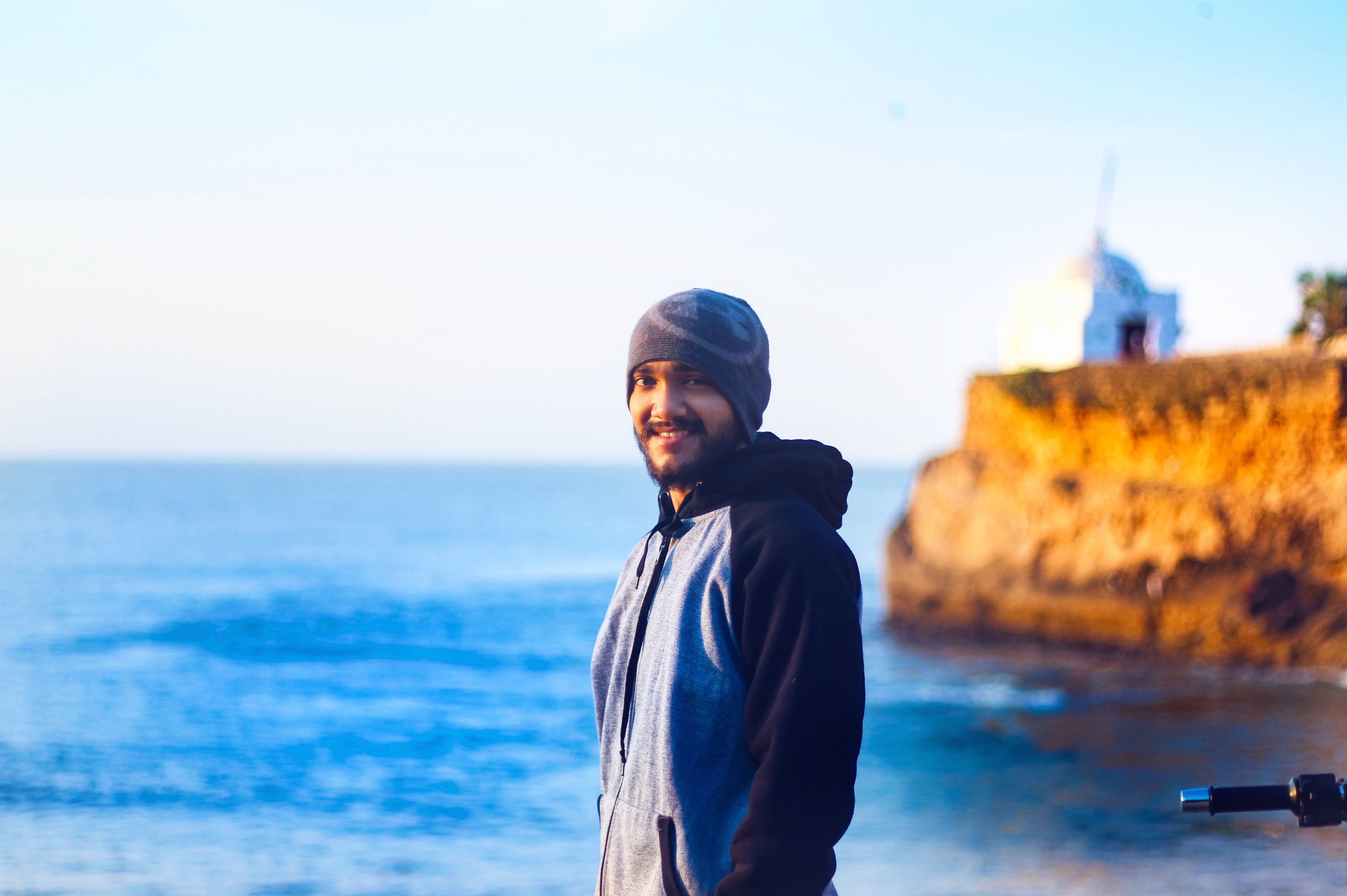 Man wearing gray knit cap and pullover hoodie beside beach photo