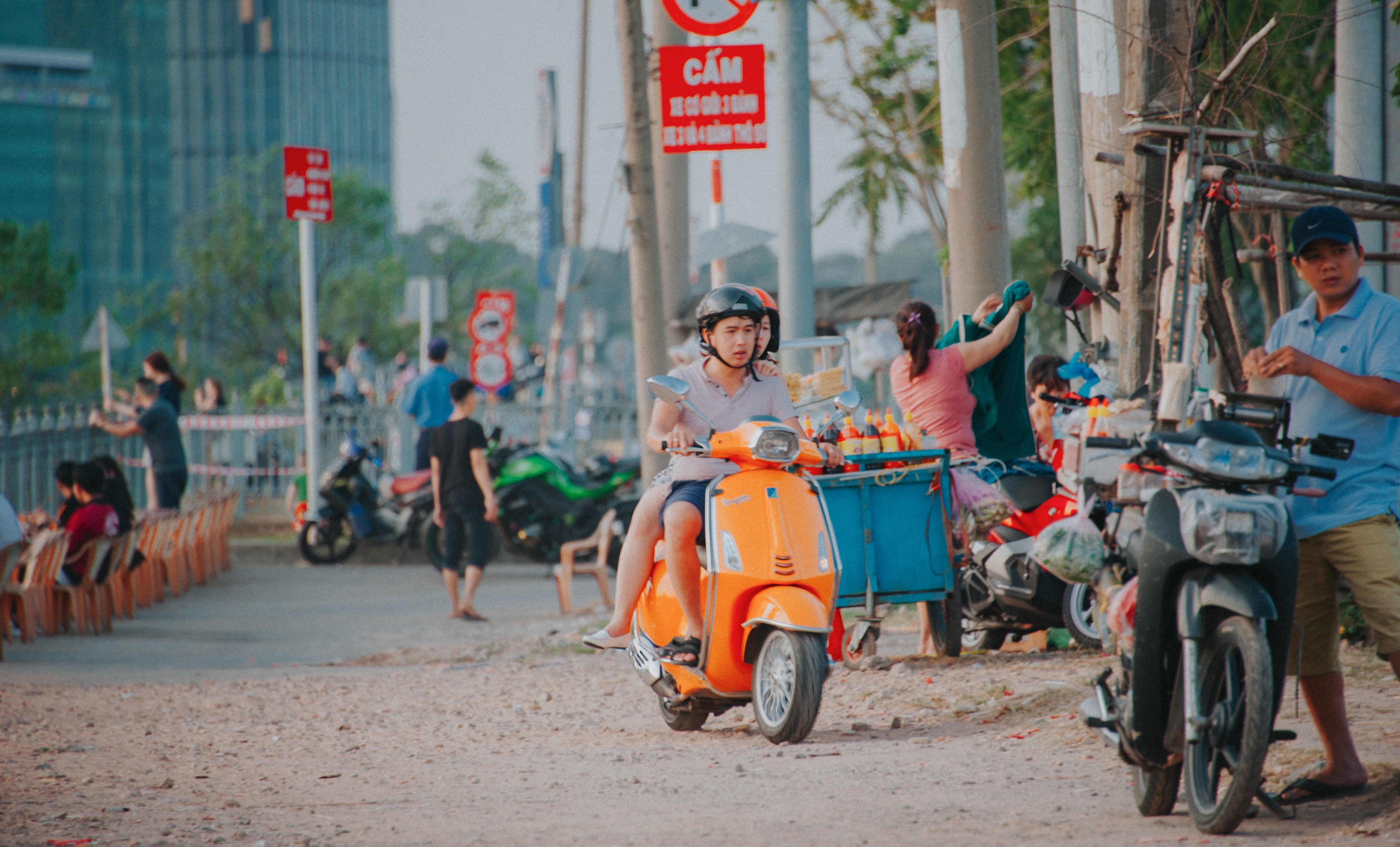 Man wearing grey shirt riding on orange motor scooter at daytime photo