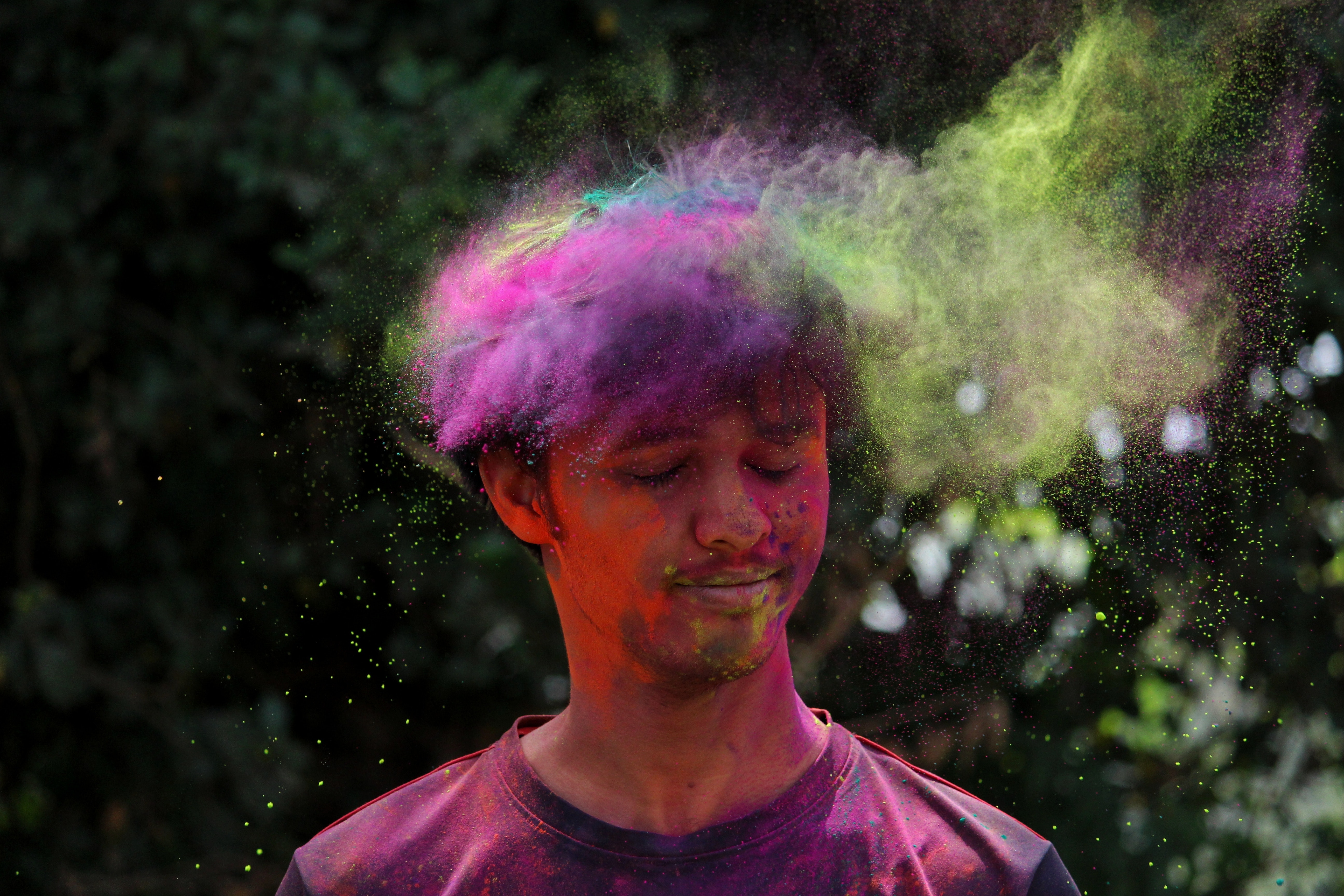 Man wearing pink crew-neck shirt with multicolored powder photo