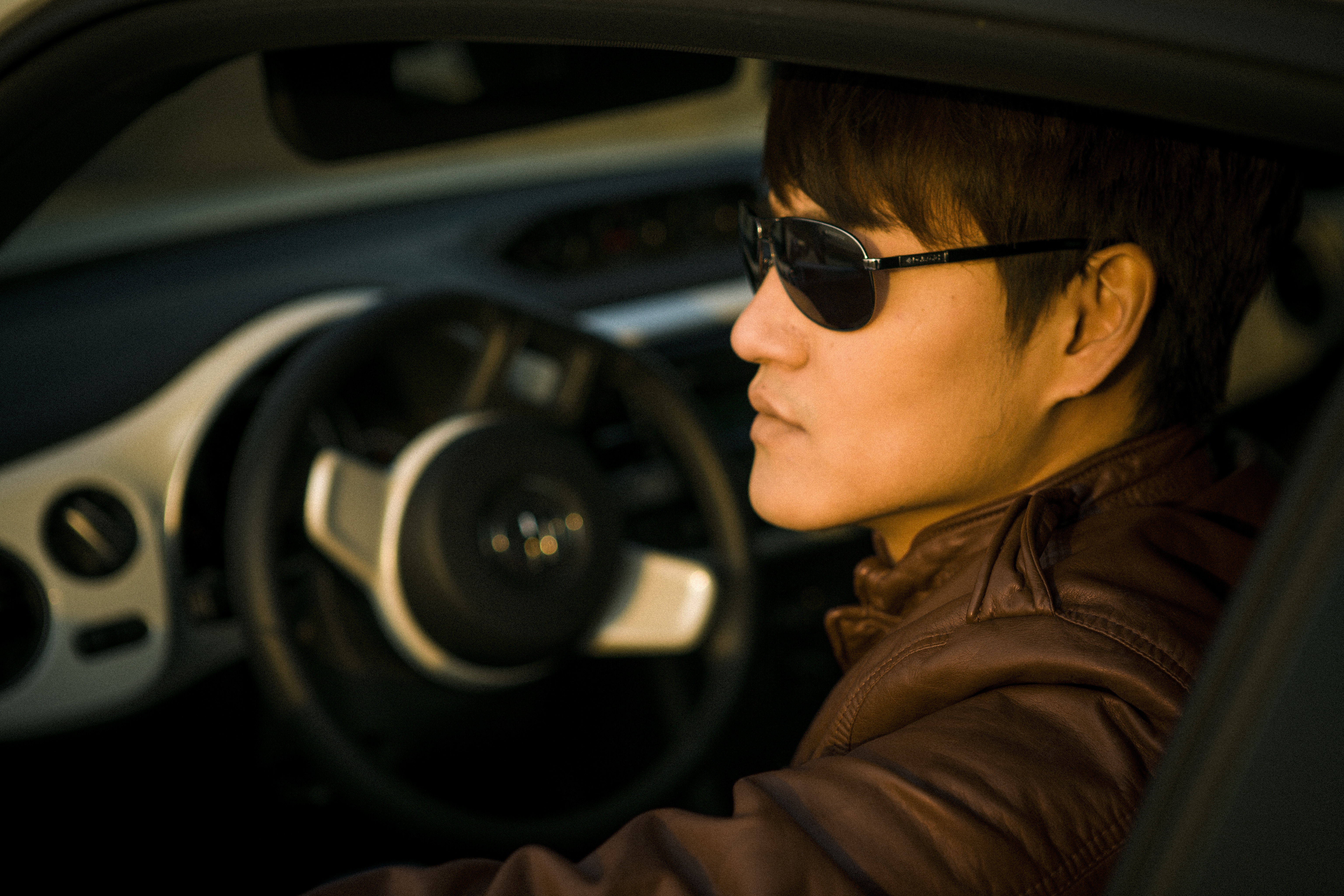 Man wearing sunglasses sitting on driver's seat photo