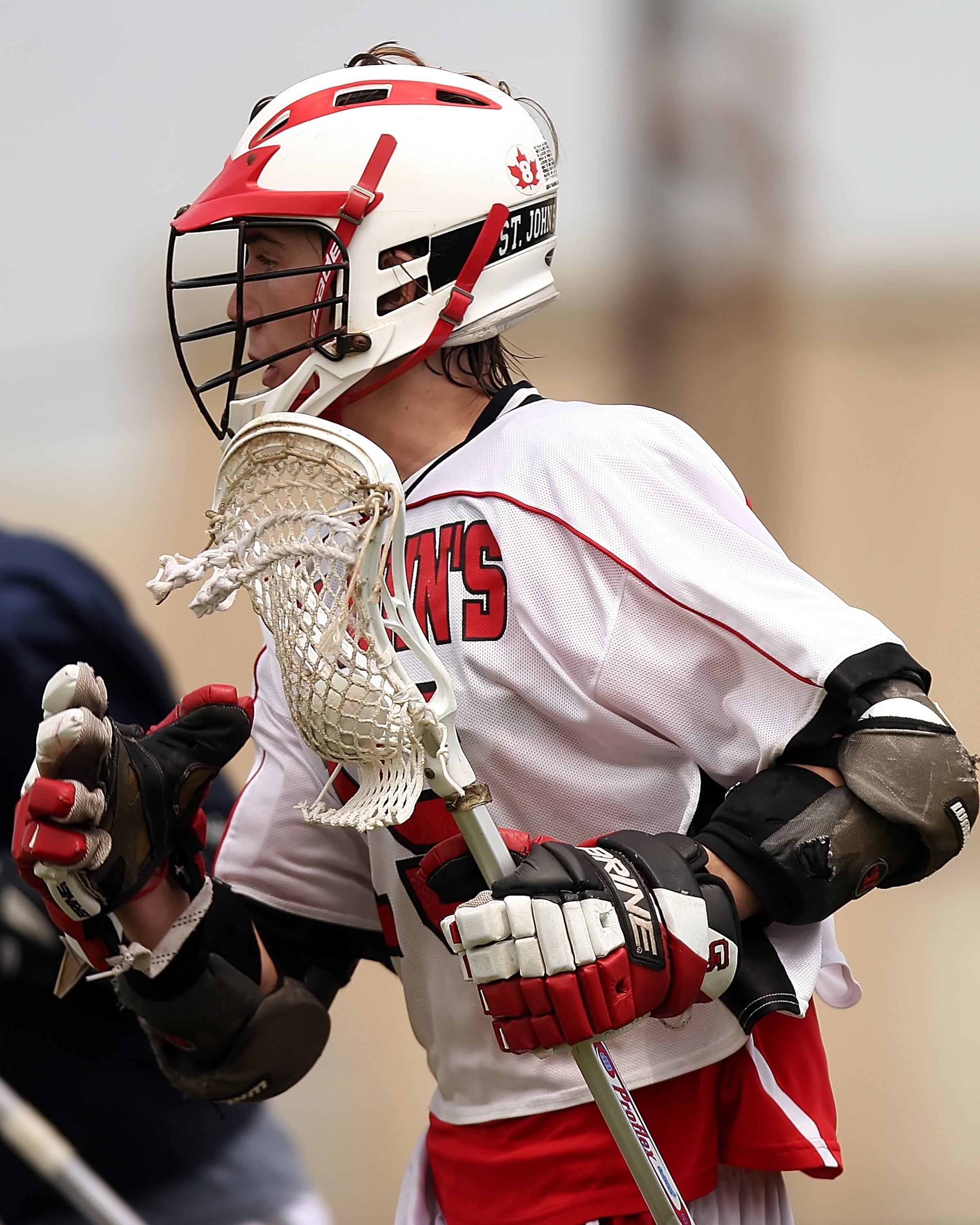 Man wearing white and red lacrosse uniform photo