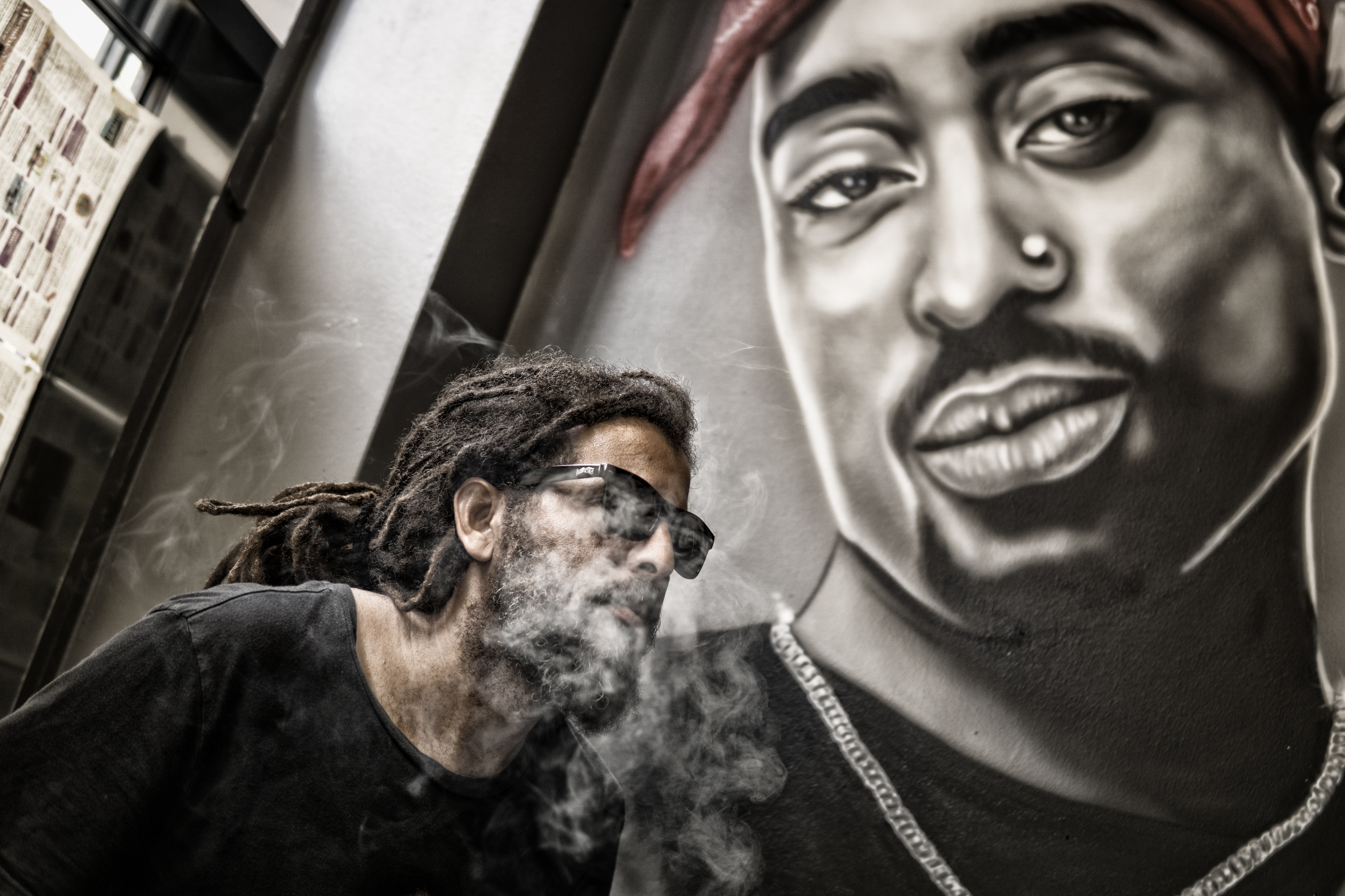 Man With Dreadlocks and Sunglasses Poses Near Tupac Shakur Portrait, Actor, Music, Wall, Urban, HQ Photo