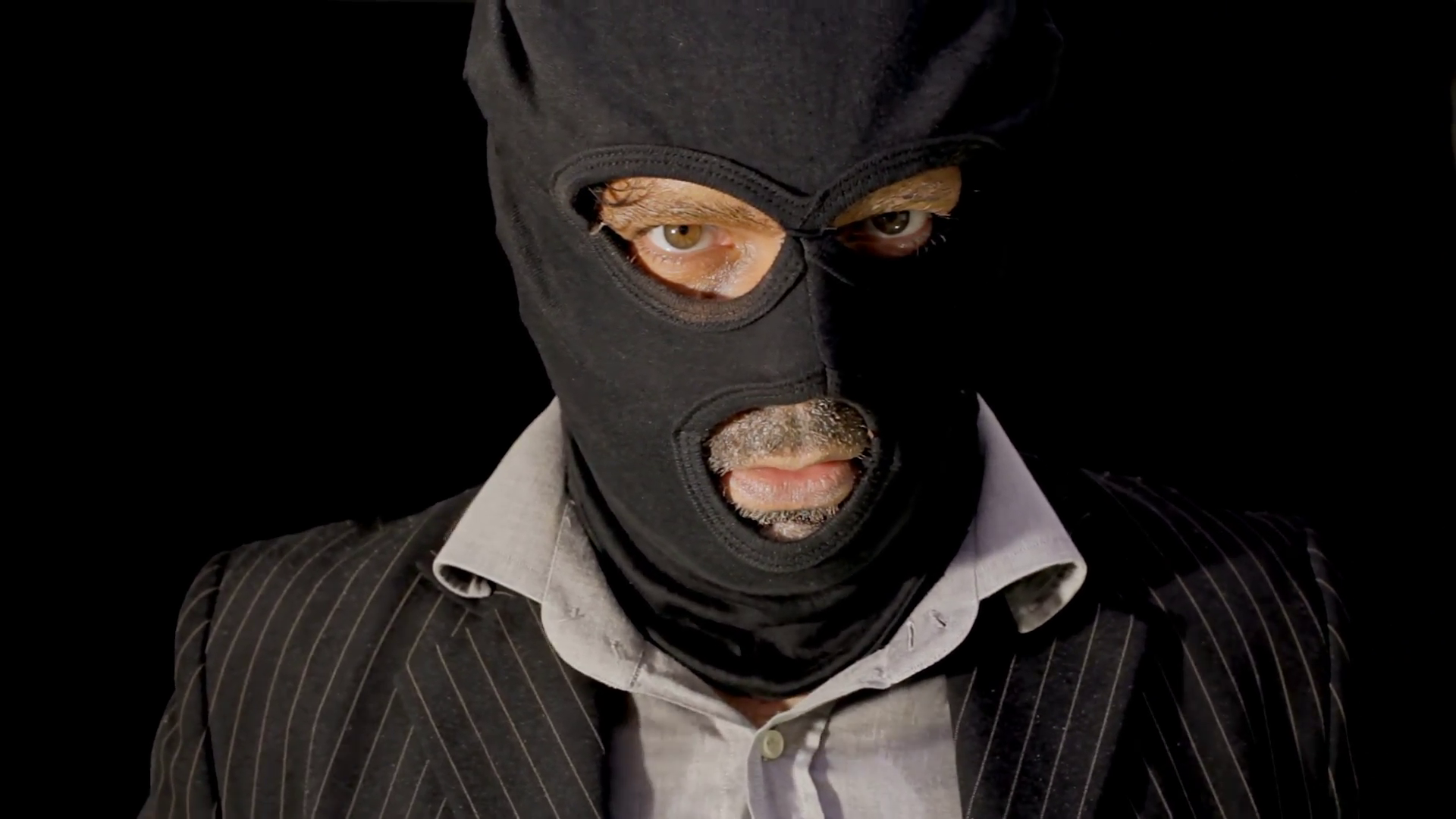 Masked criminal showing up laughing close up. A masked man, robber ...