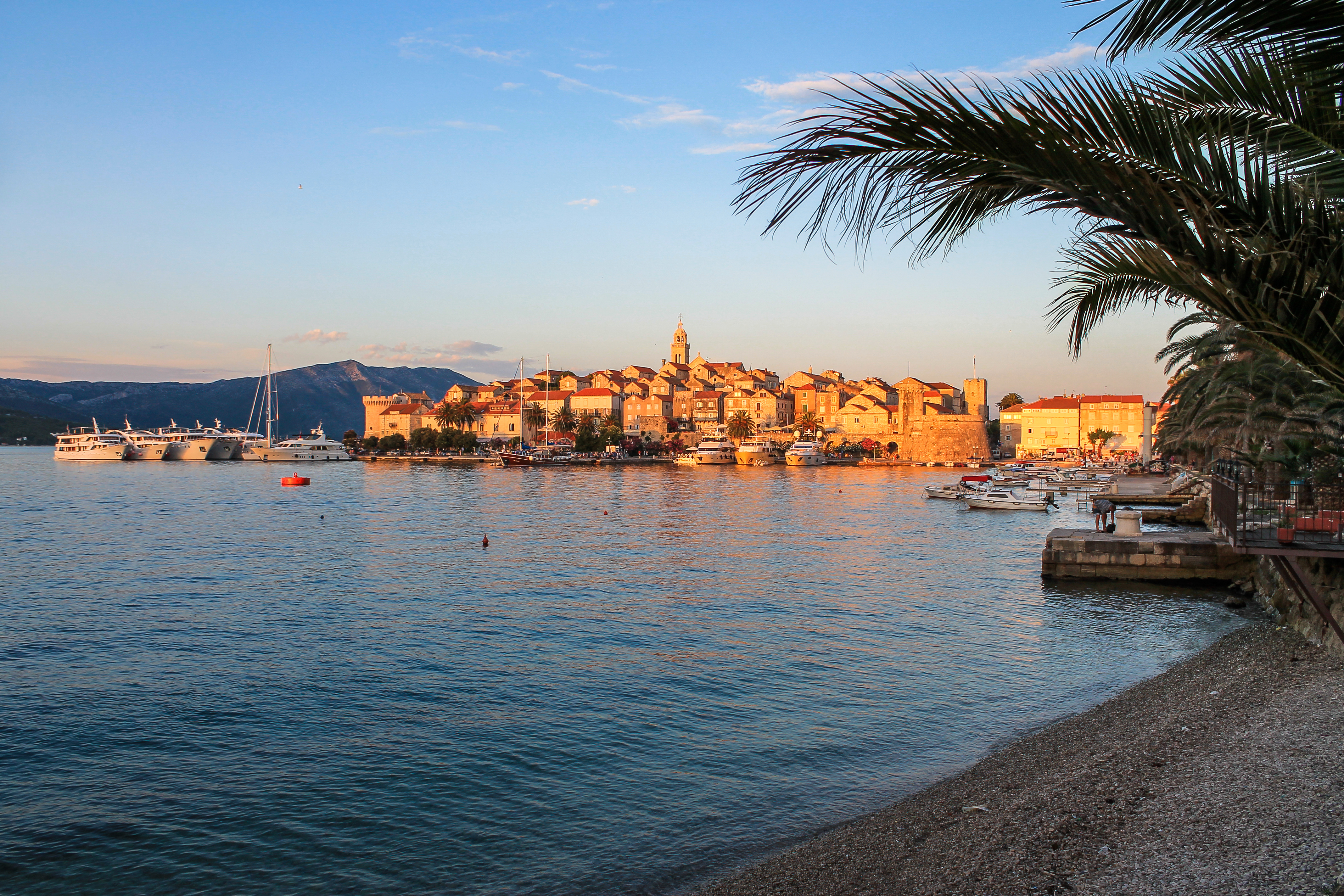 Medieval town at sunset with palm trees and beach photo