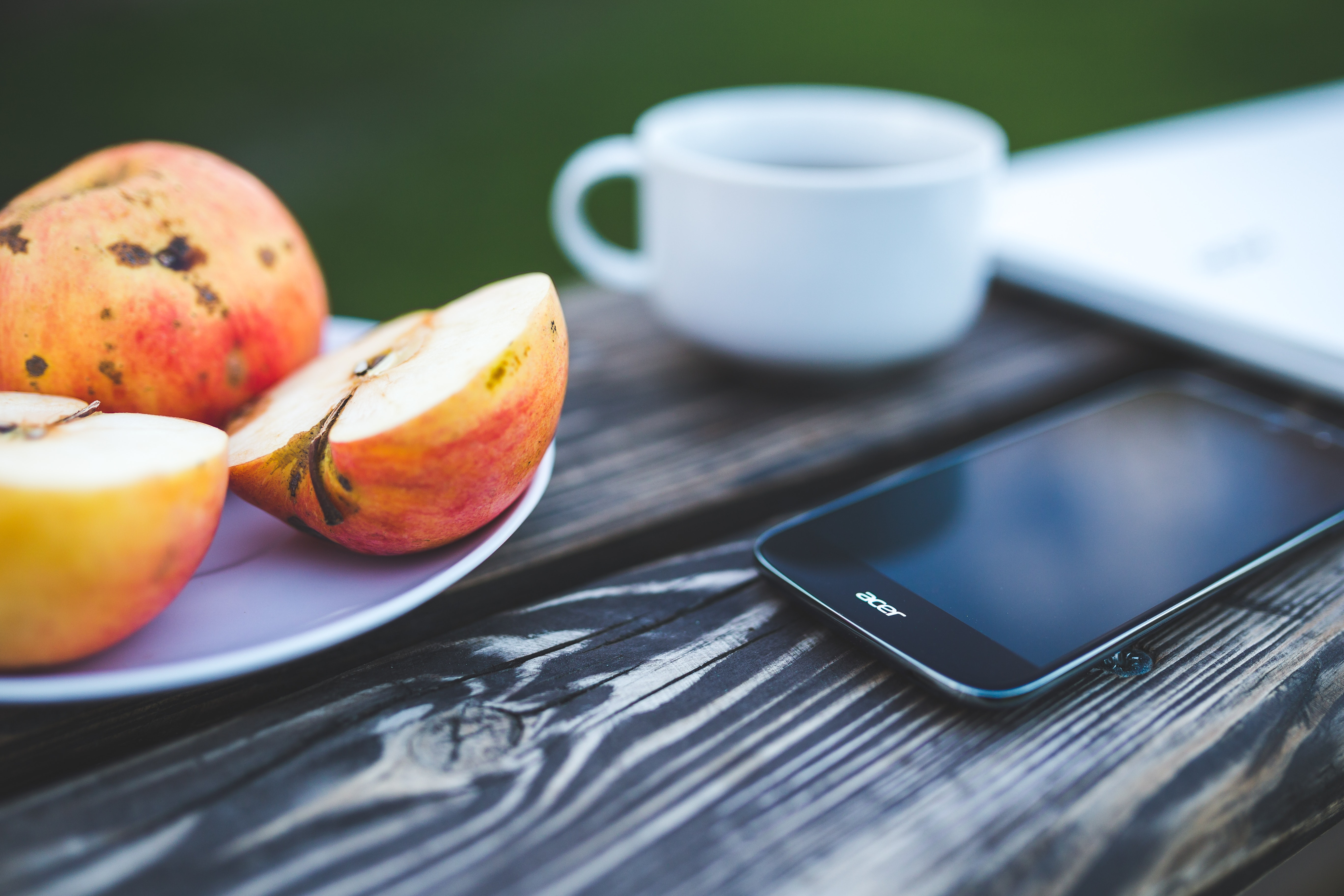 Mobile phone, apple, coffee on the wooden table photo