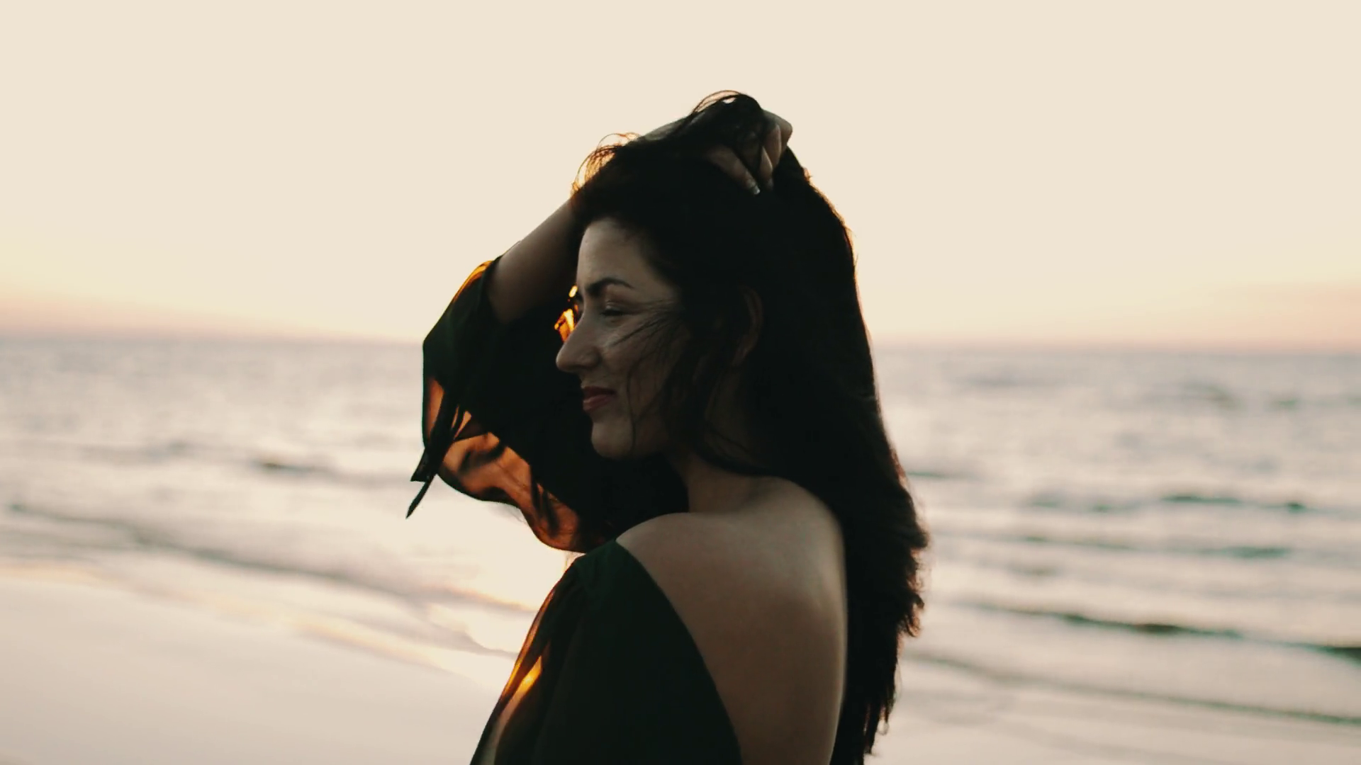 Girl in dark dress posing to photographer on beach. Photoshoot. Sea ...