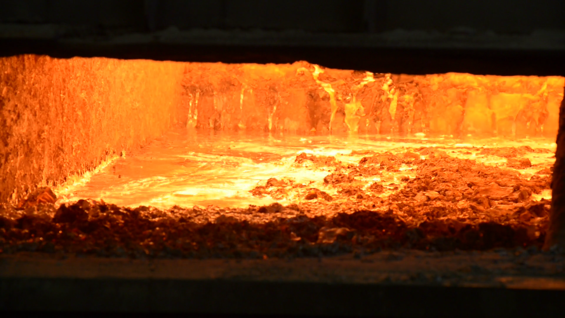 Molten metal in the melting furnace. Steelmaker removes slag from ...