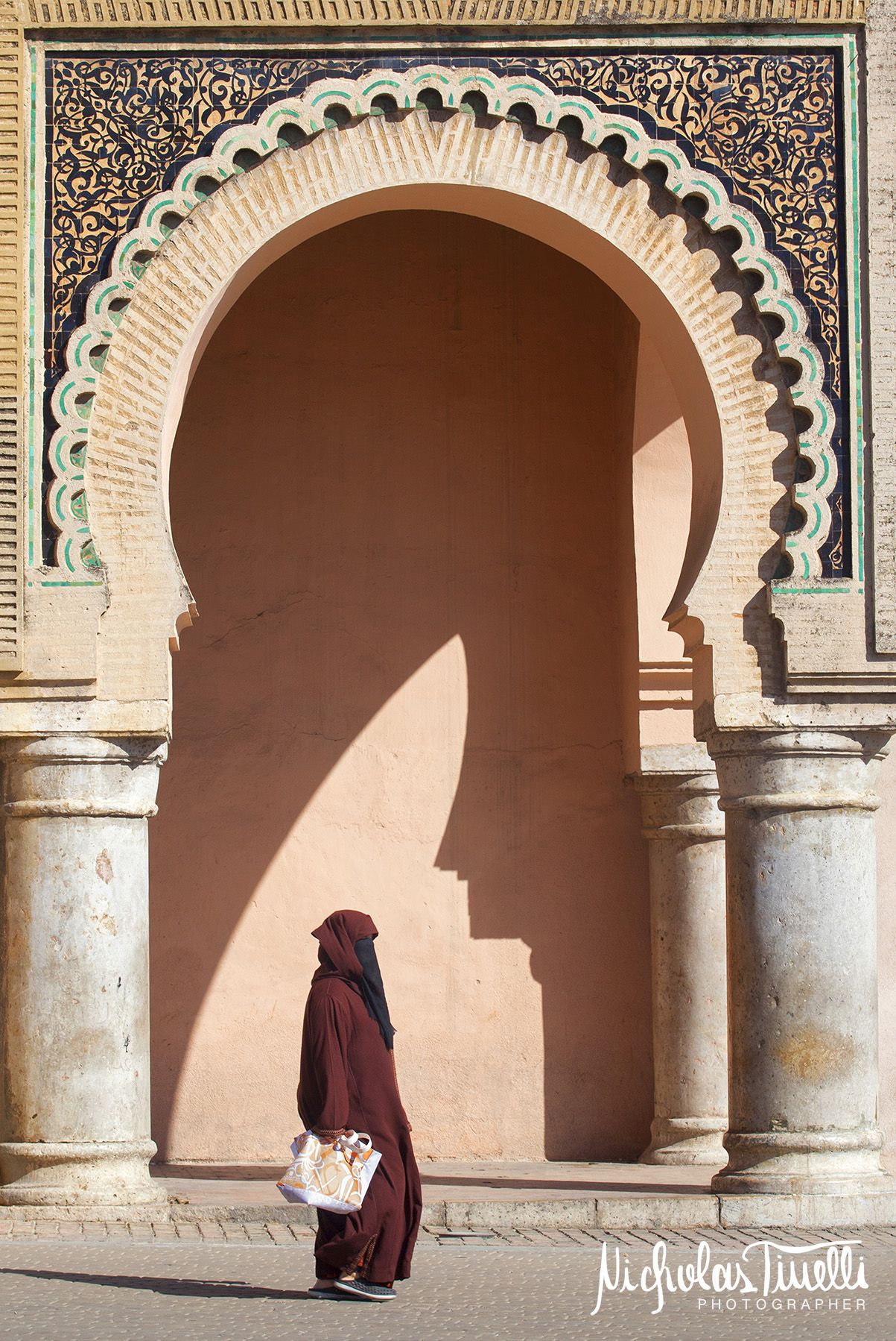 A woman in traditional Moroccan clothes in front of the 