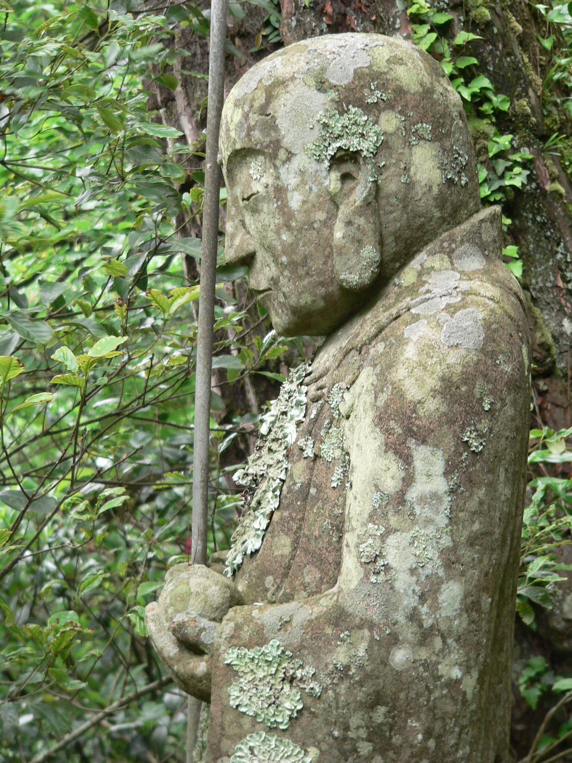 Moss covered japanese jizo bodhisattva statue photo