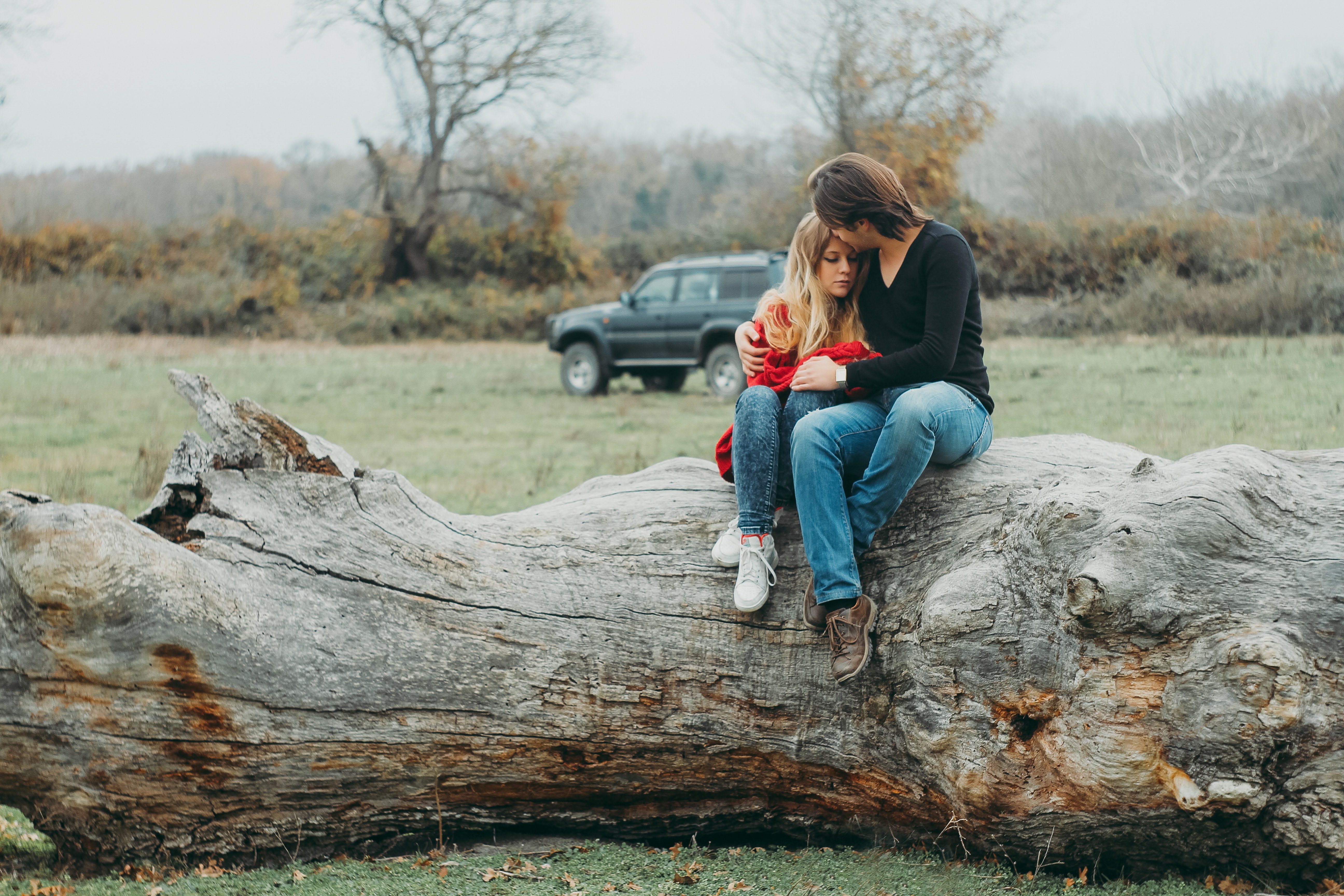 Mother and daughter sitting on tree log photo