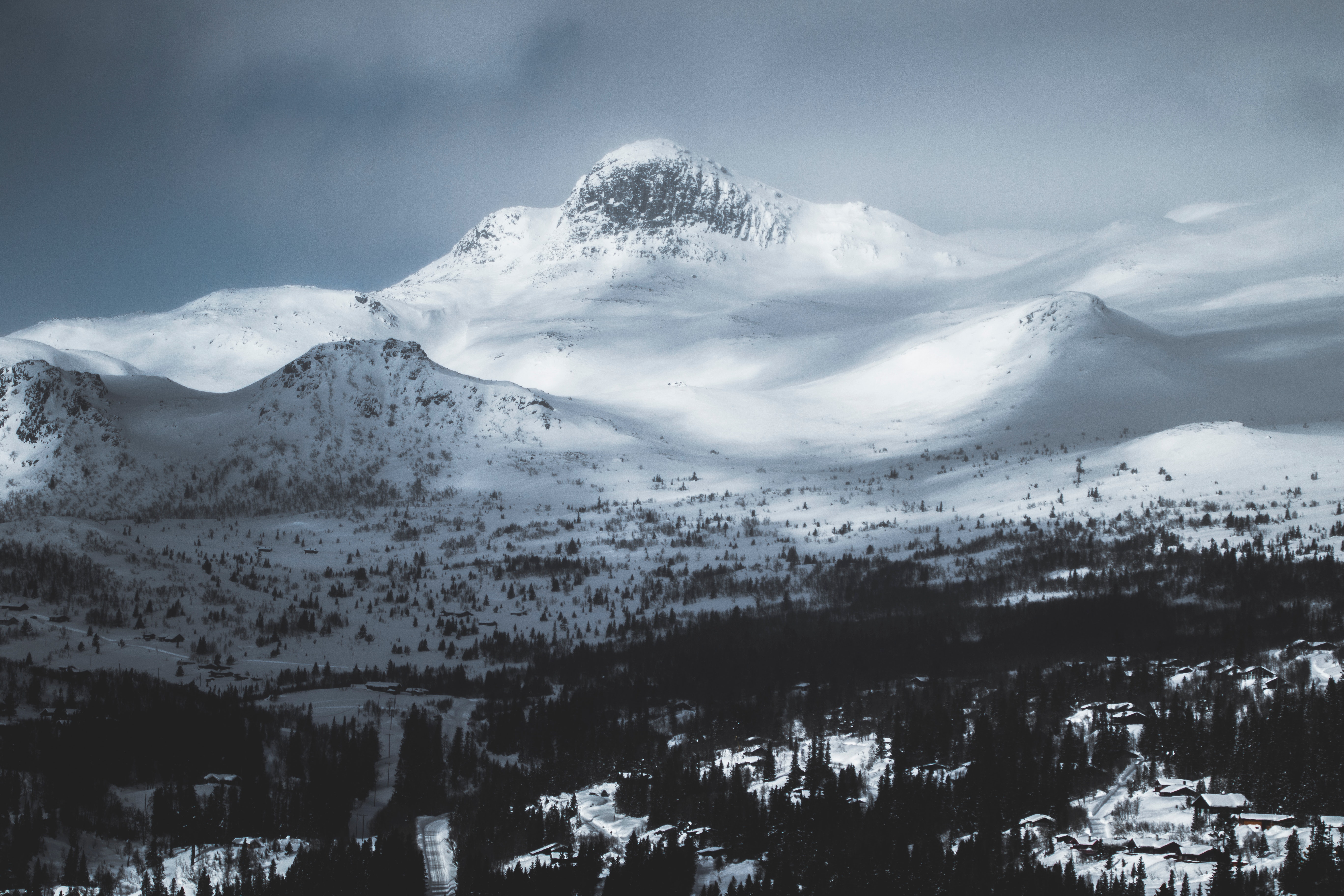 Mountain coated with snow under gray sky photo