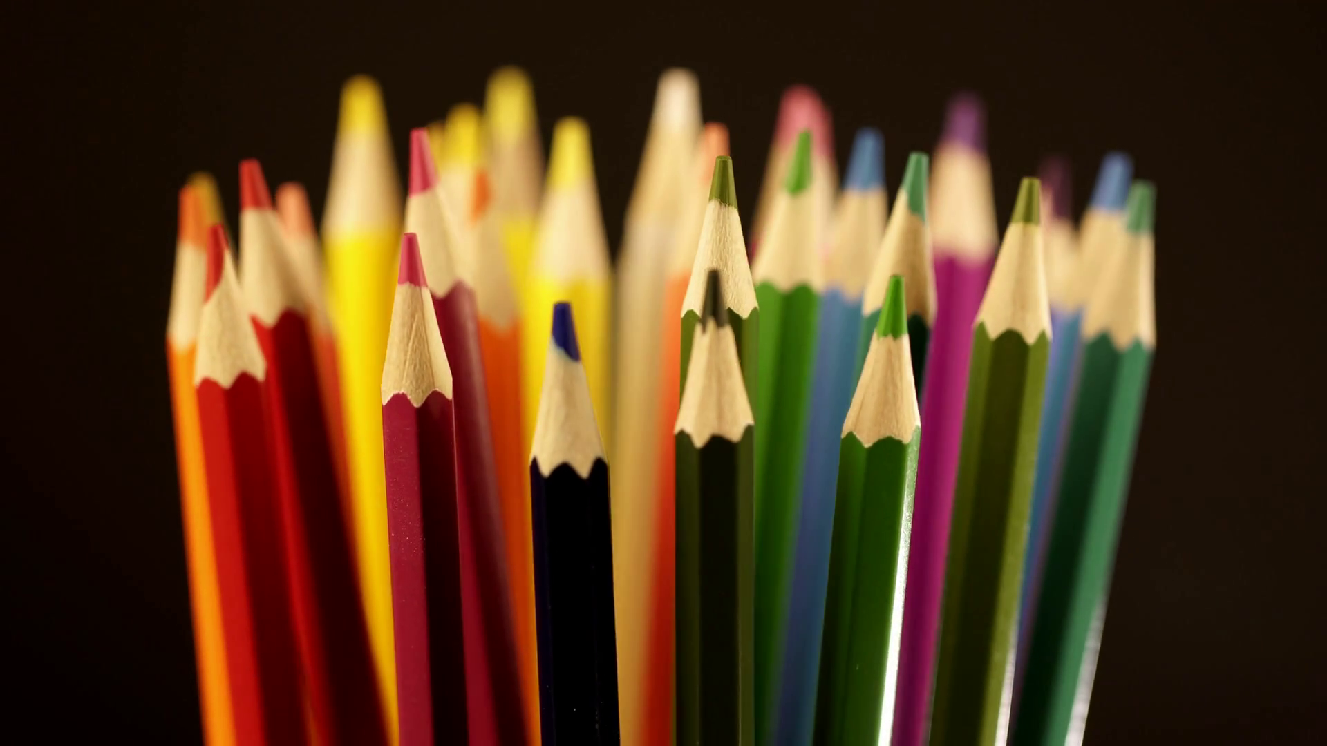 Top of color pencils. Color pencils turning on a black background ...