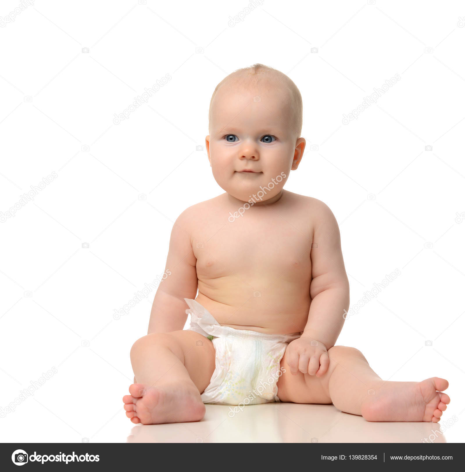 Infant child baby girl toddler sitting naked in diaper looking a ...