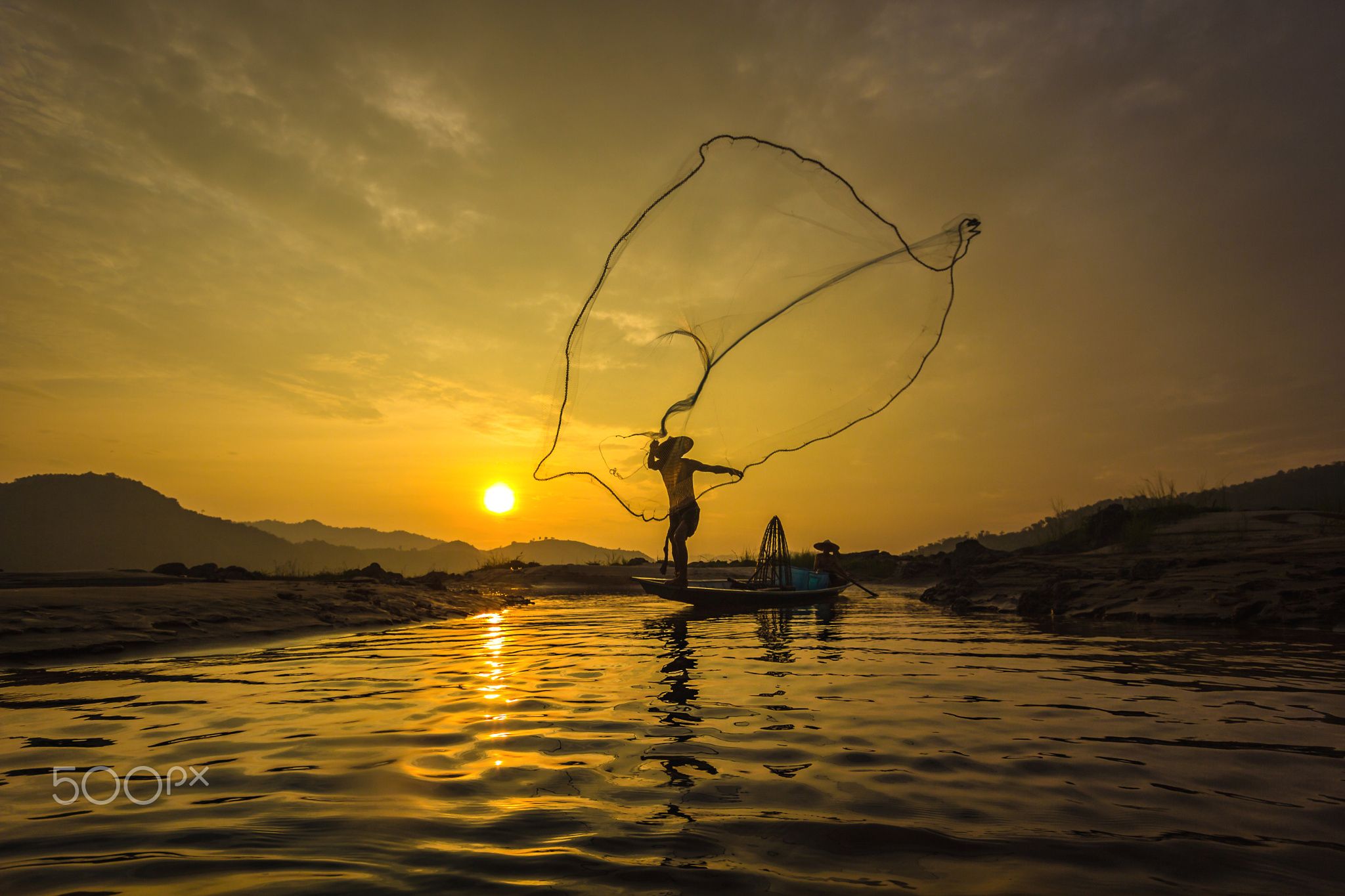 Fishermen fishing nets - Fishermen fishing nets during sunset in the ...