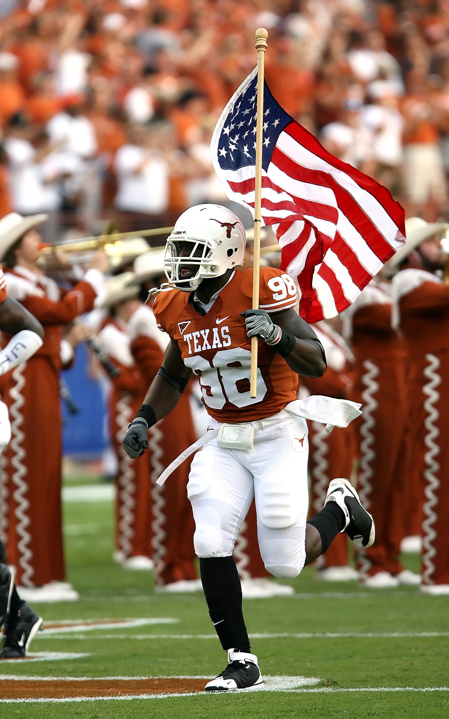 Nfl player holding u.s.a. flag on field photo