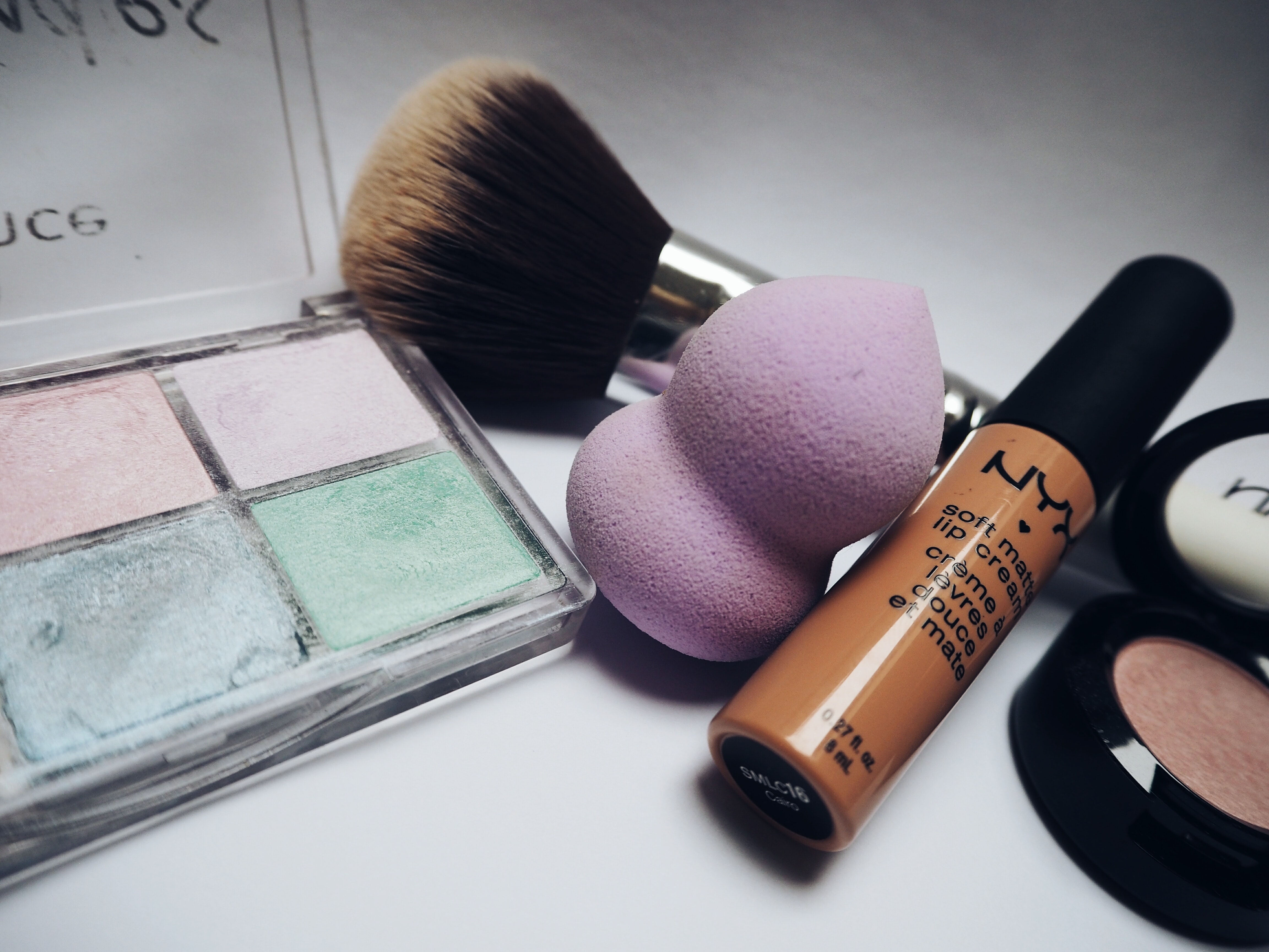 Nyx lipstick beside eye shadow palette photo