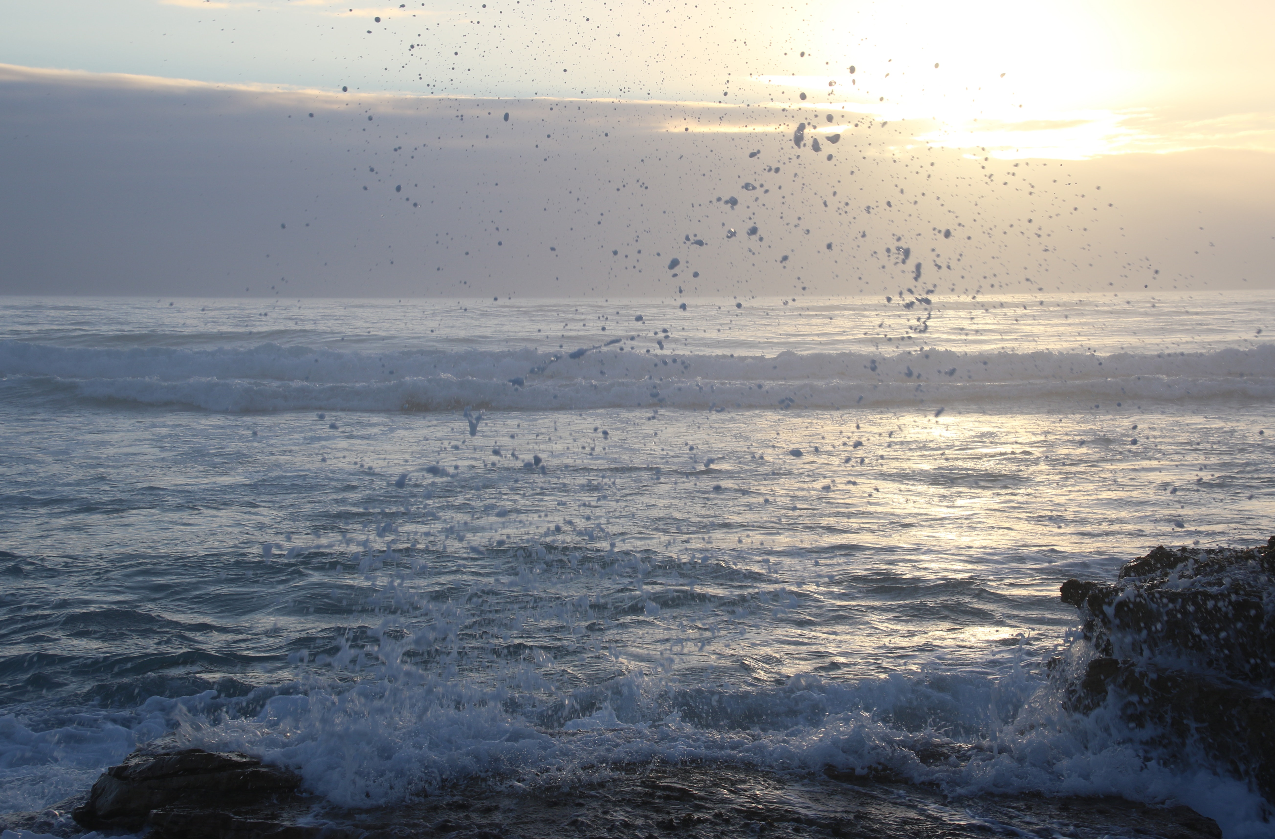 Ocean waves hammering rock boulder photo