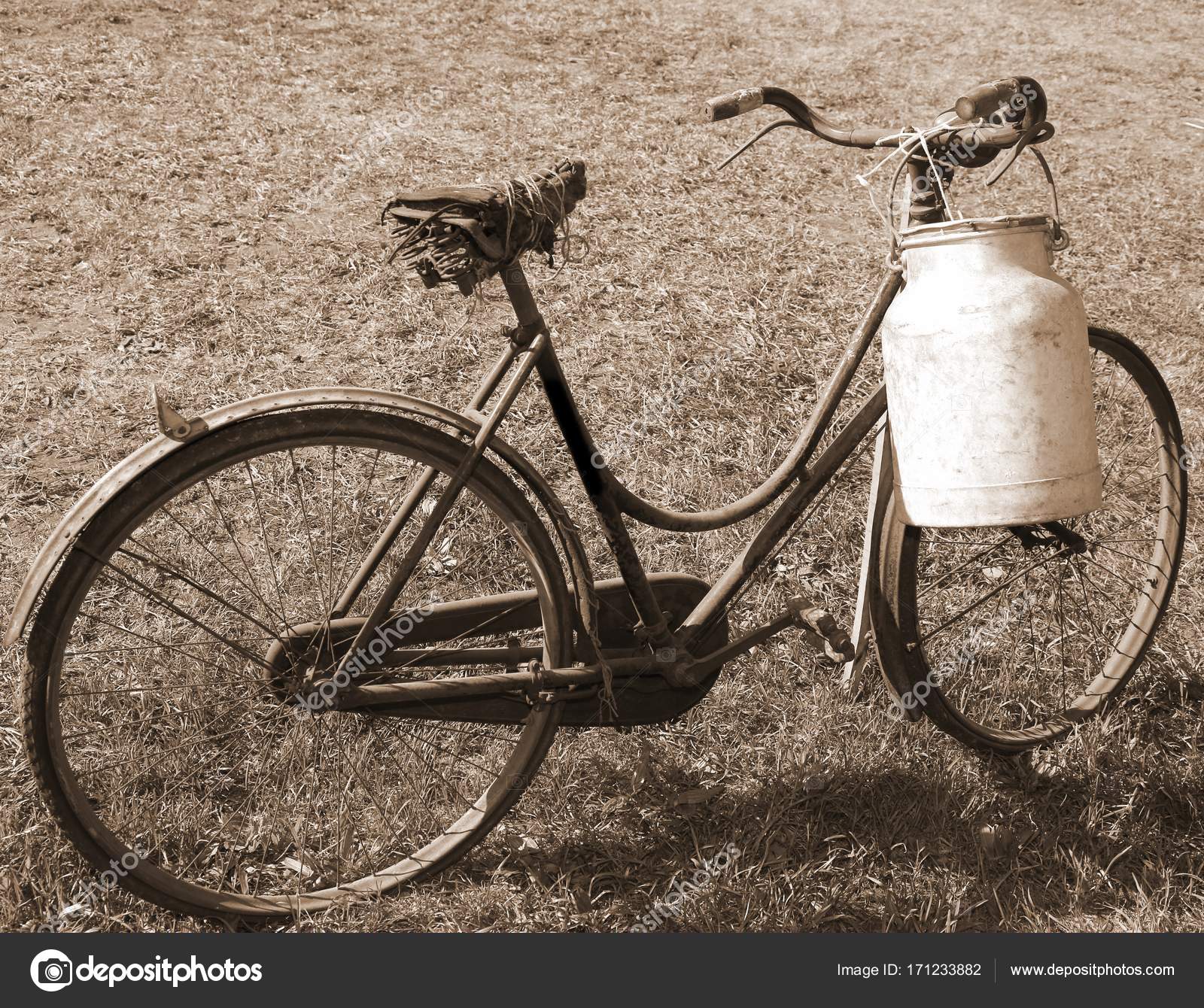 very old bicycle with a broken saddle and the milk can milkman ...