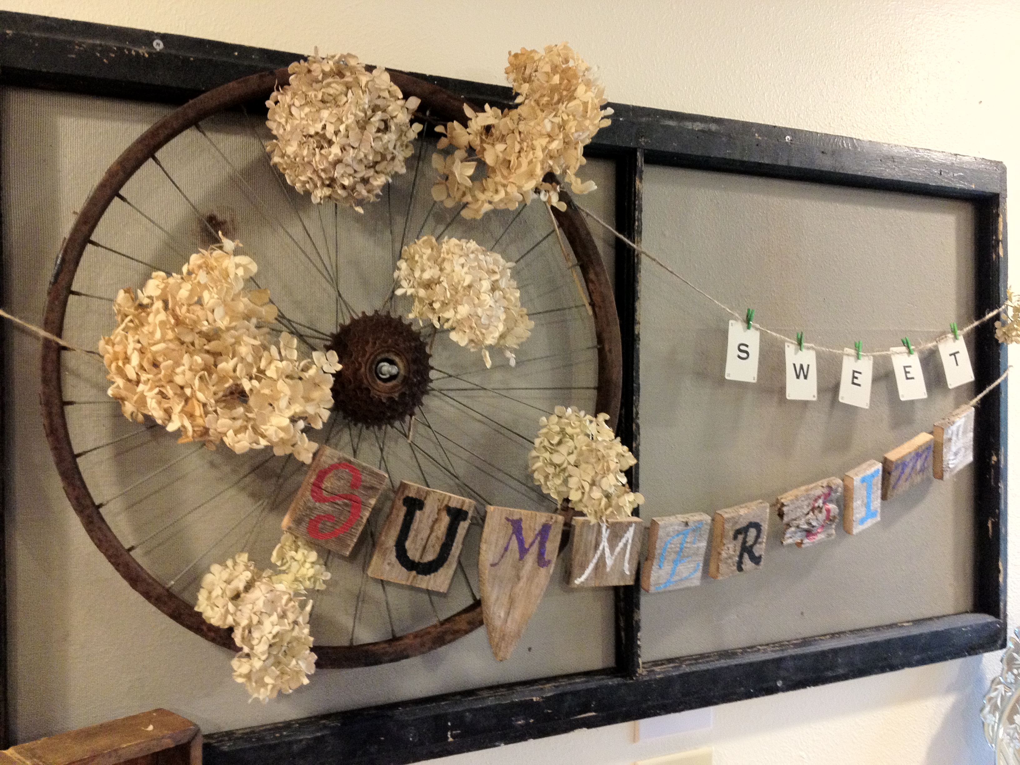 Vintage bike wheel and hydrangea wreath with an old wood banner ...