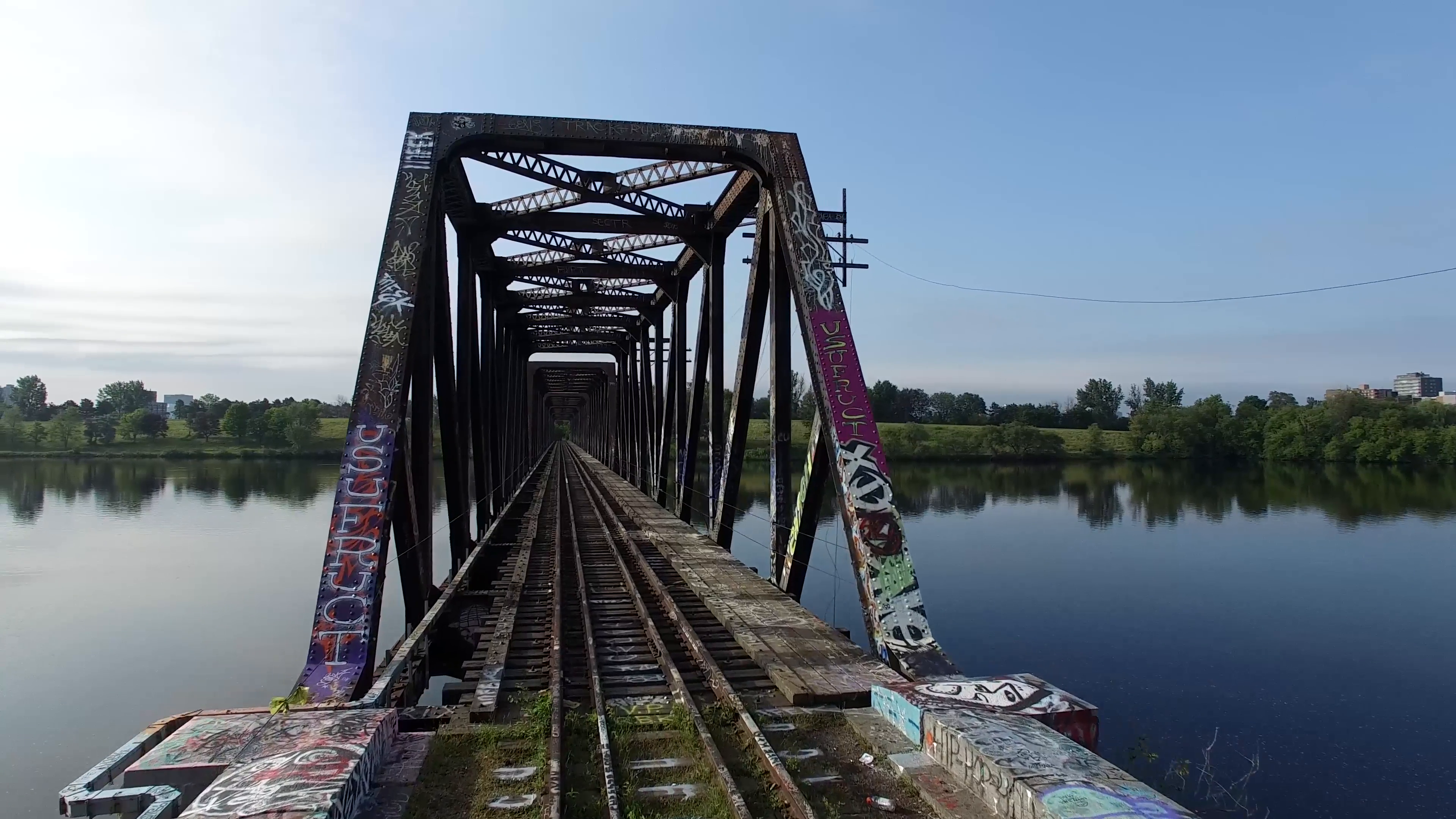 Cinematic aerial of camera flying towards old train bridge with ...