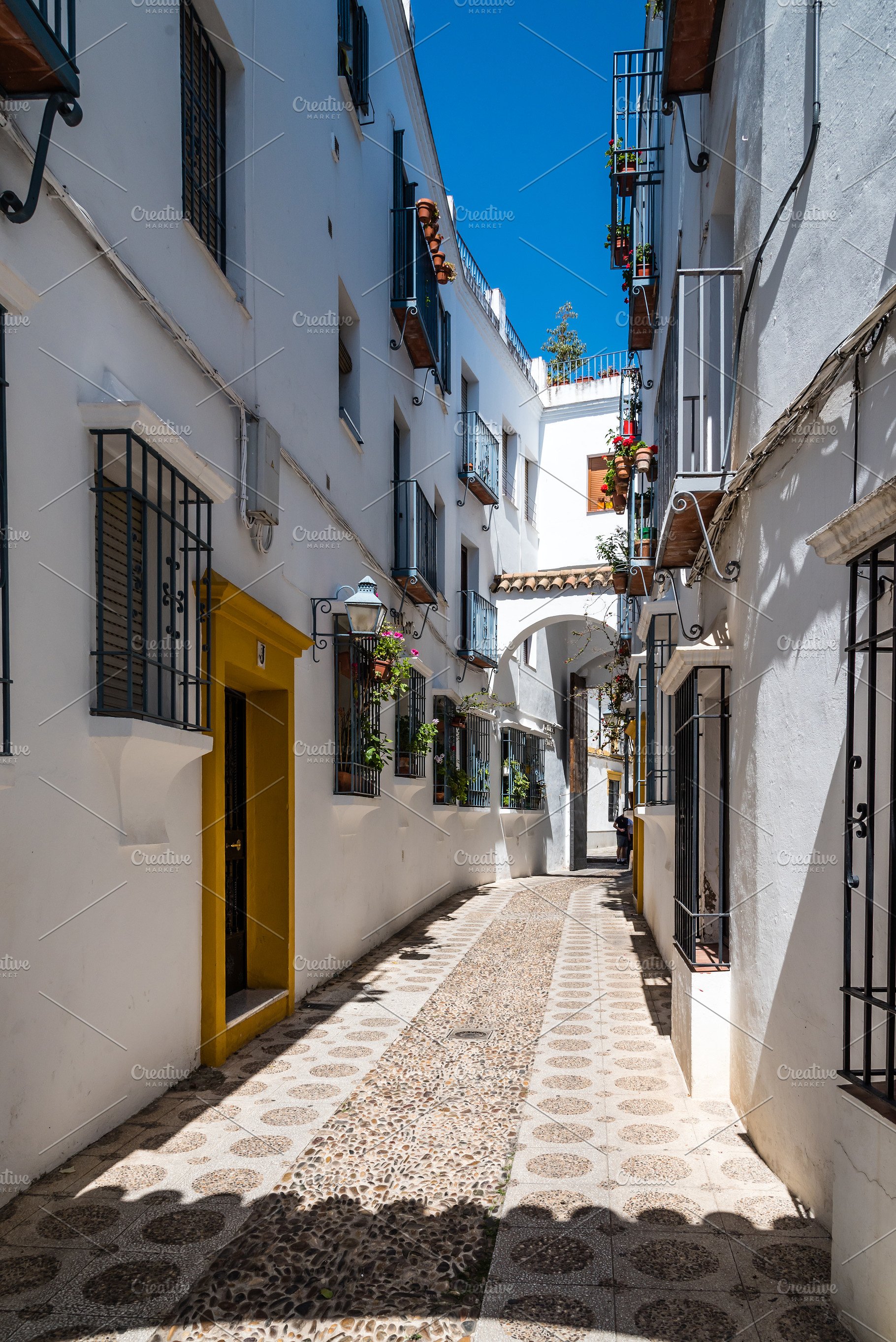 Old typical narrow street in the jewish quarter of Cordoba with ...