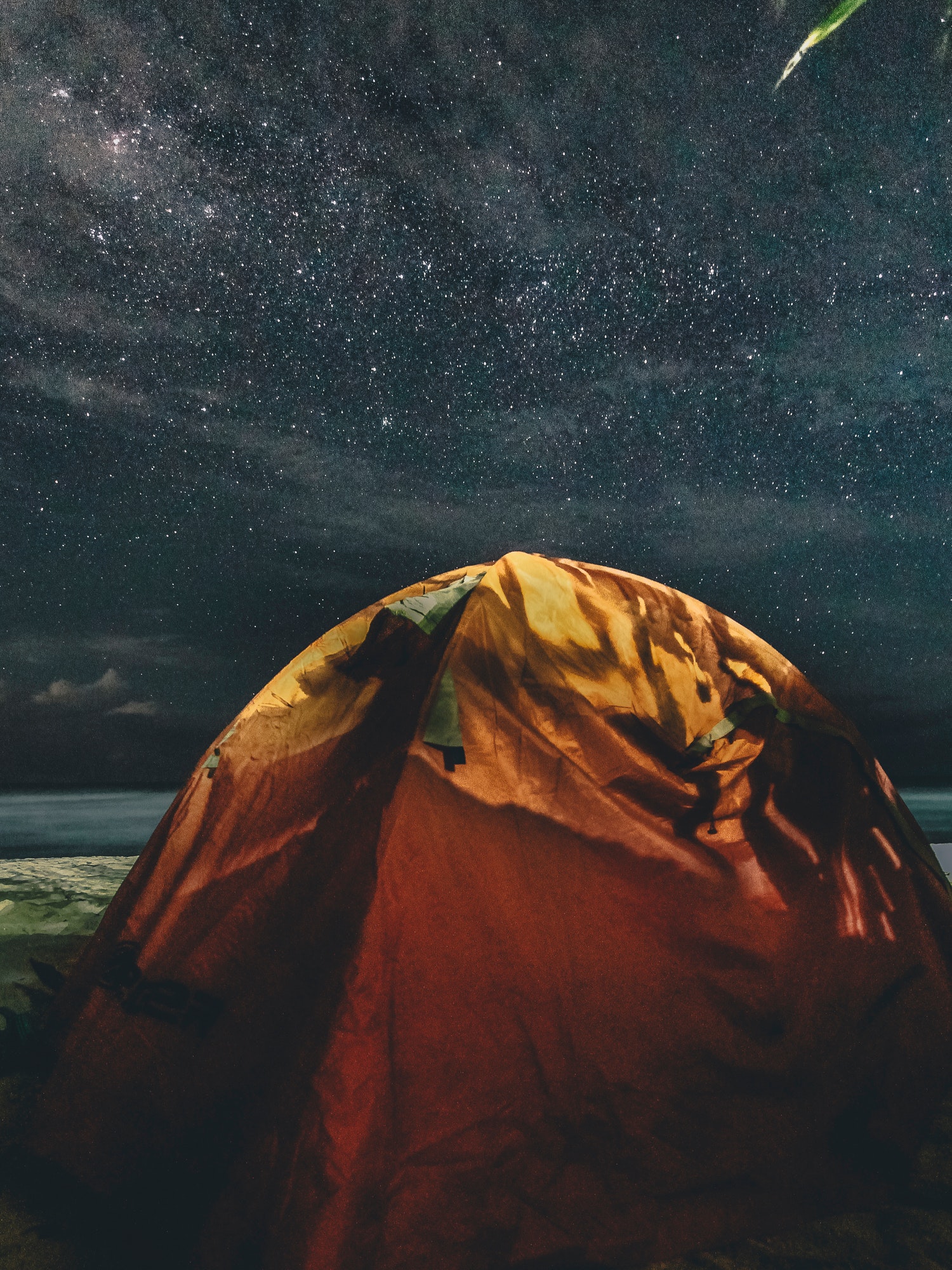 Orange and green camping tent under starry sky photo
