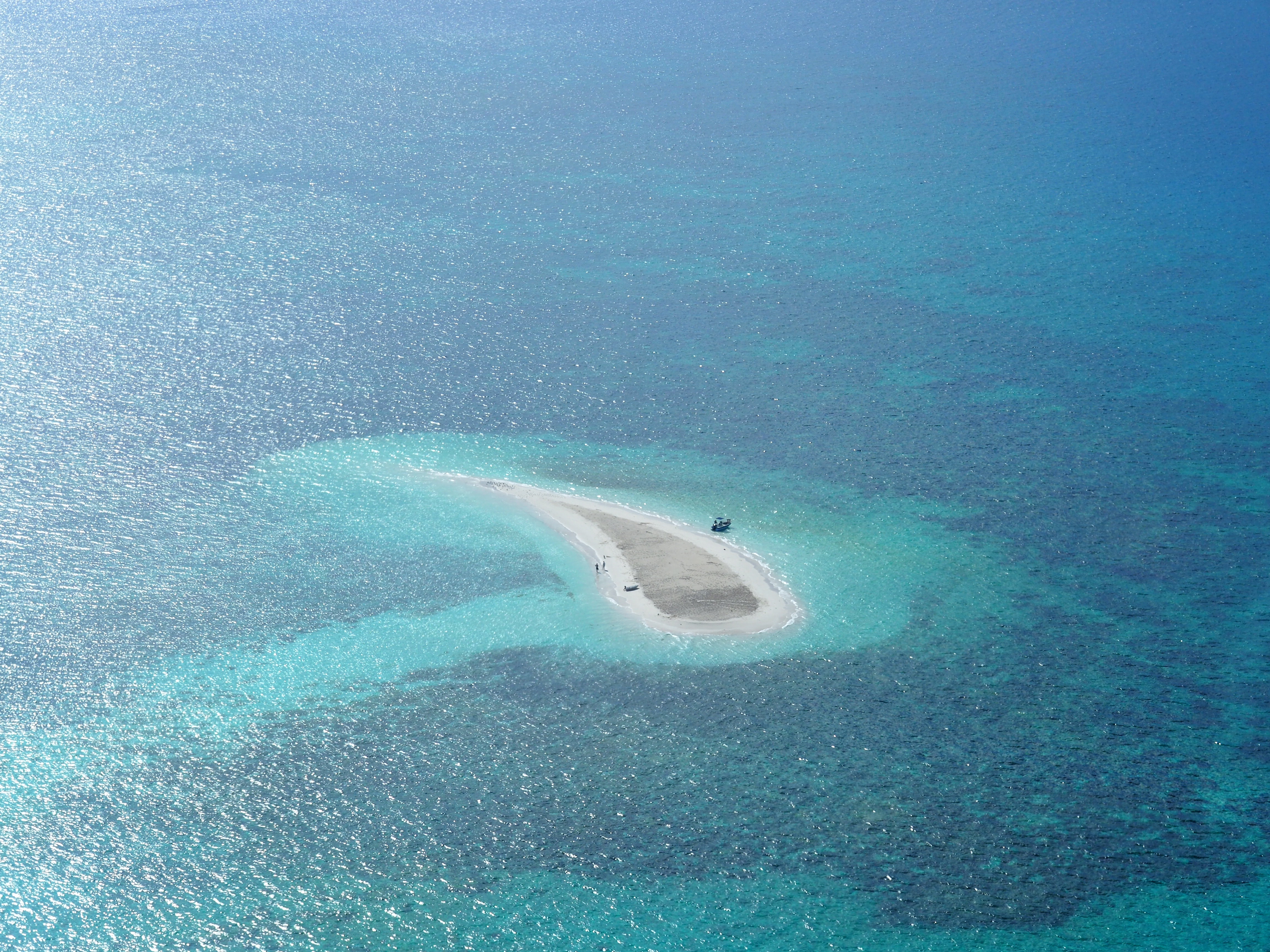 Oval white sand island at daytime photo