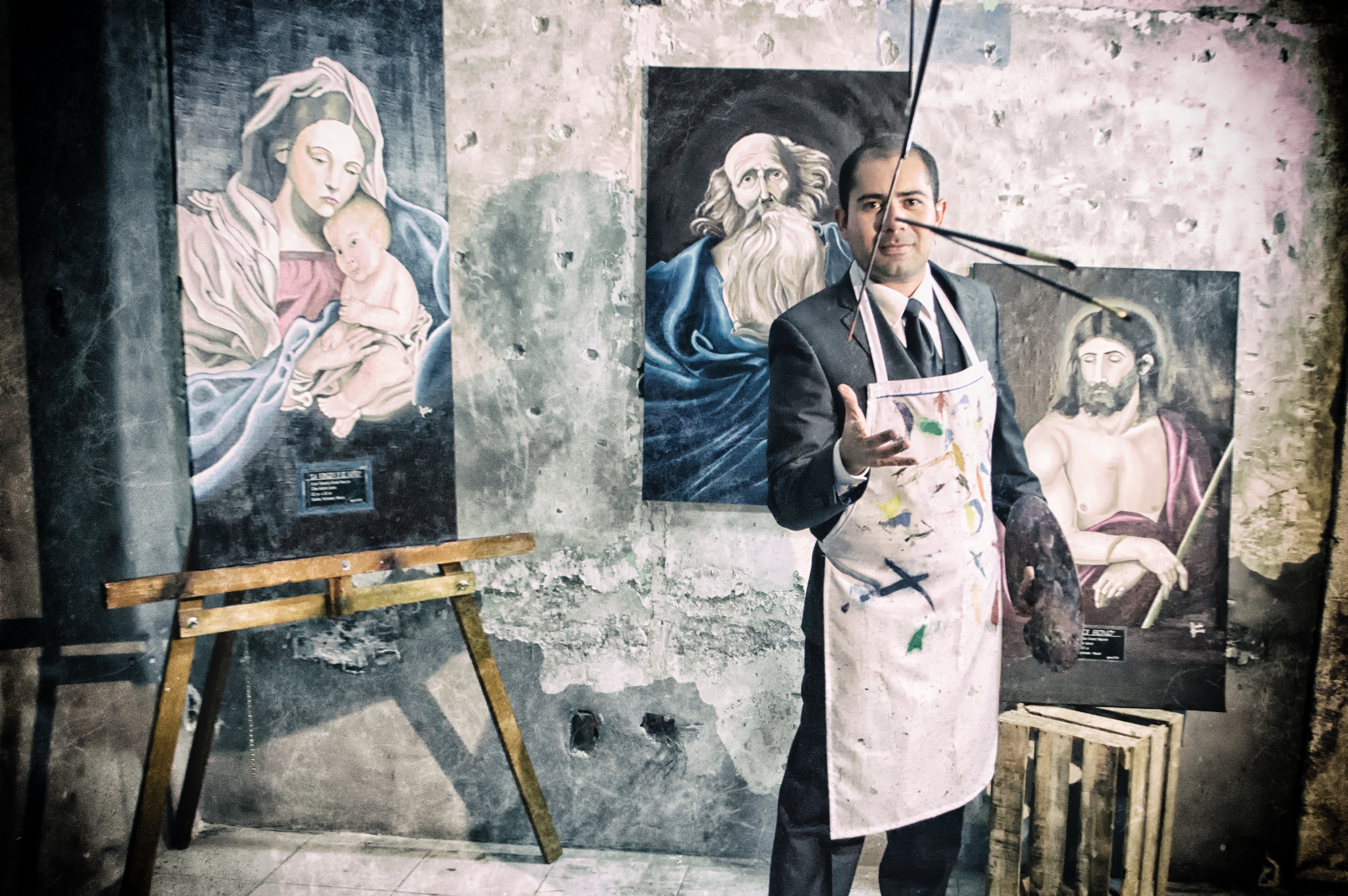 Painter with apron beside portrait paintings photo
