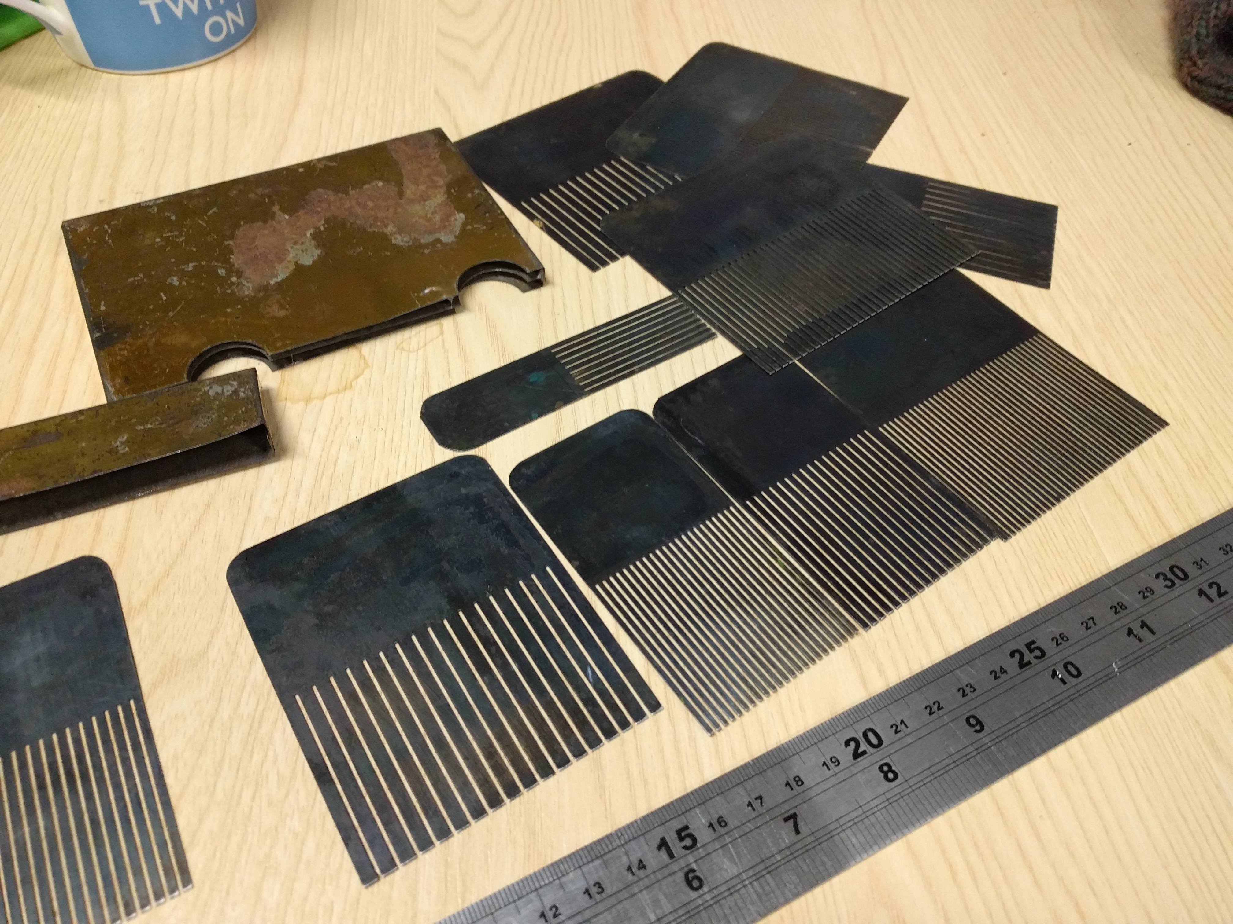 Several steel combs in a handmade tin box, various sizes of comb ...